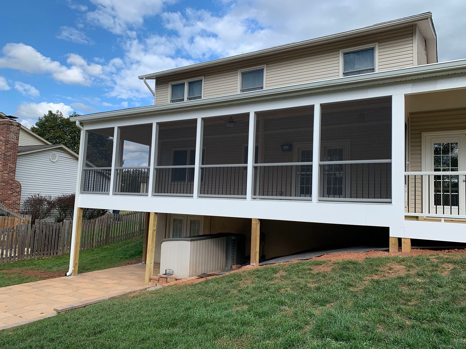 A house with a screened in porch on the side of it.