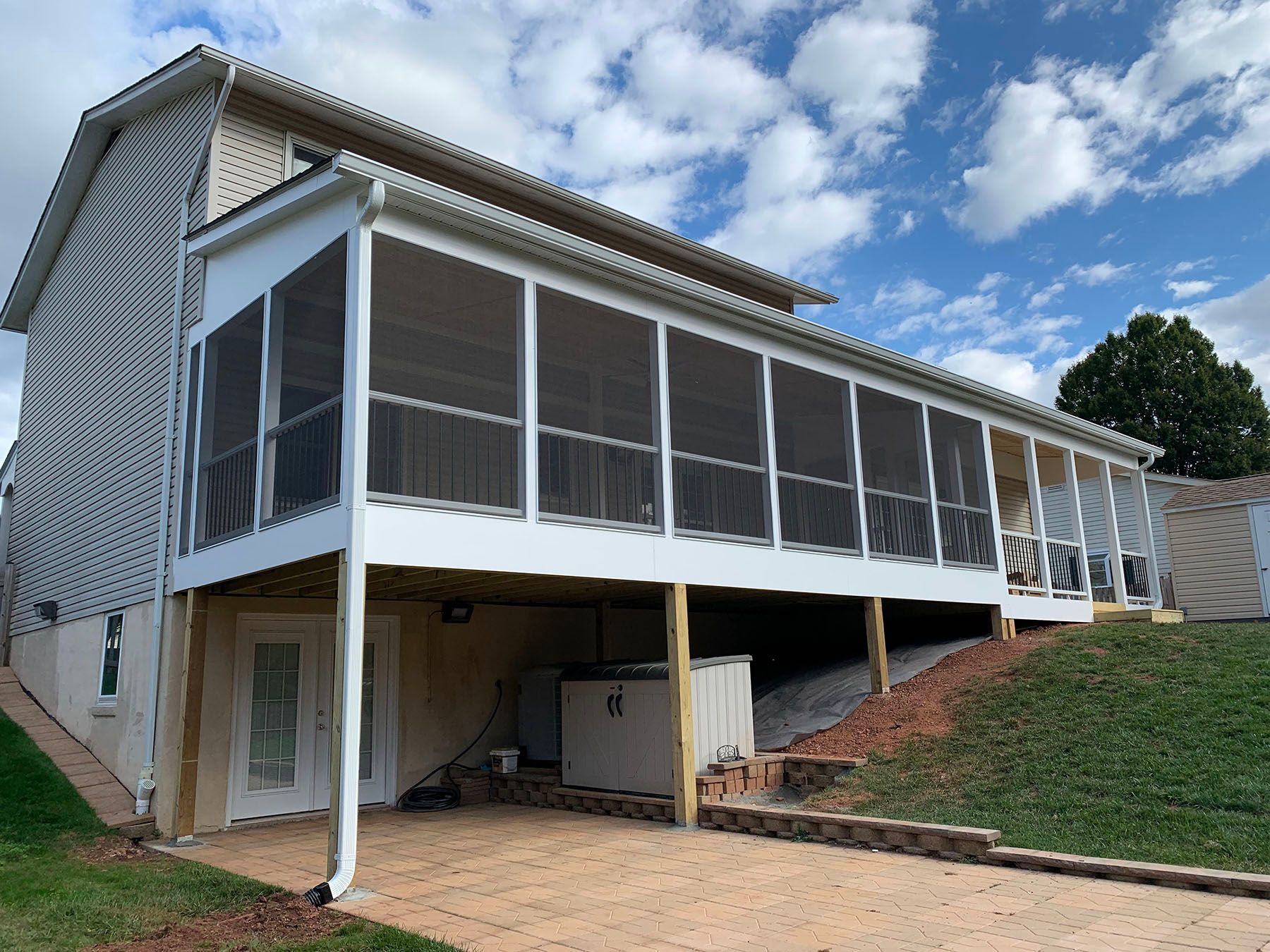 A house with a screened in porch on the side of it.