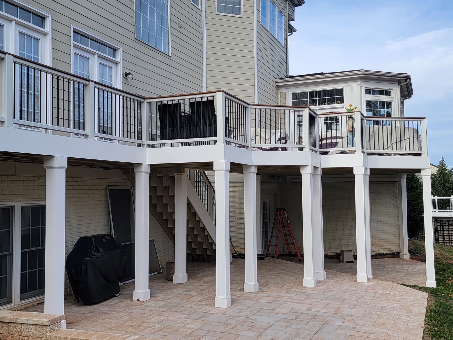 The back of a house with a large deck and stairs.