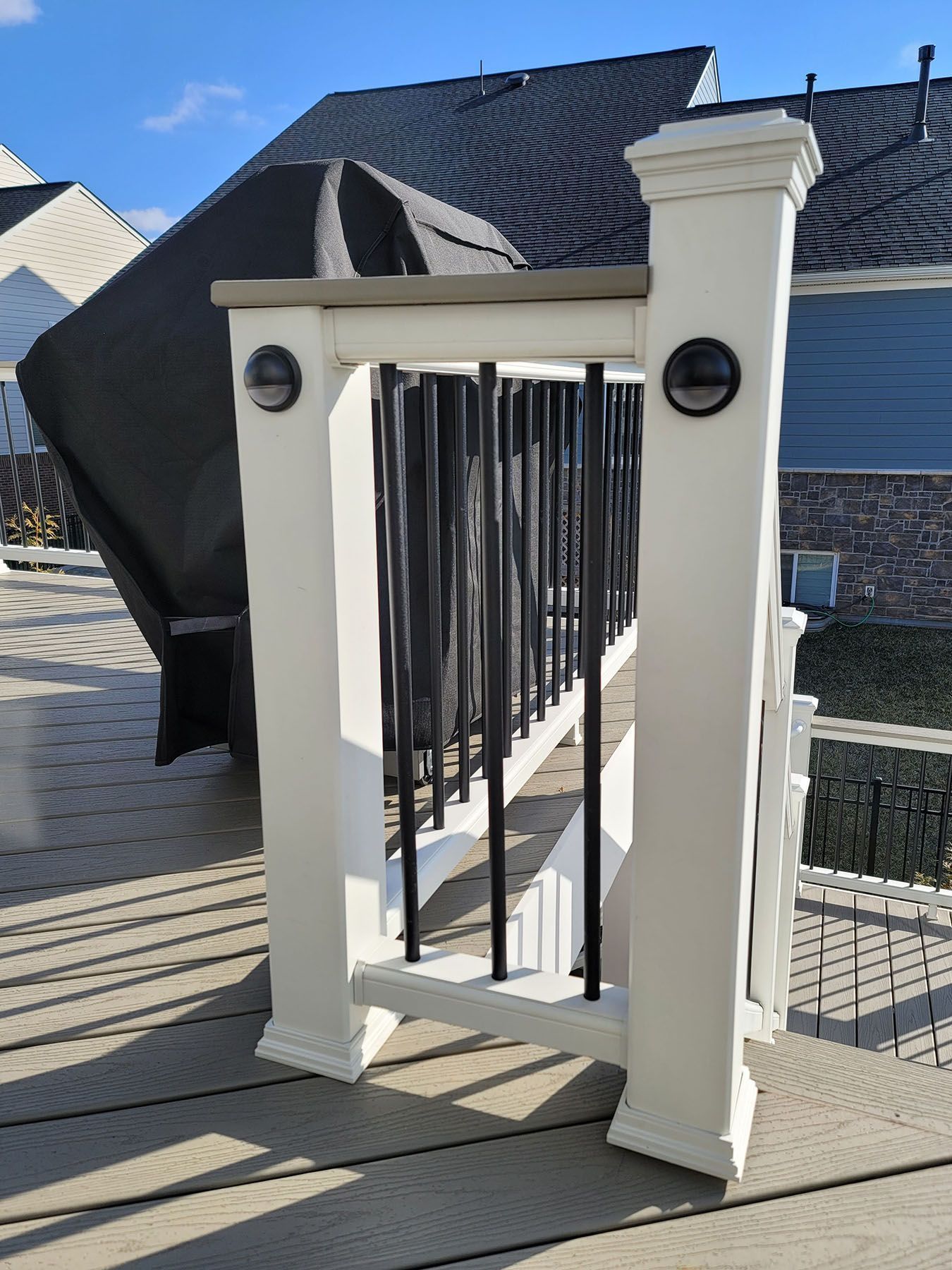 A white railing is sitting on top of a wooden deck.