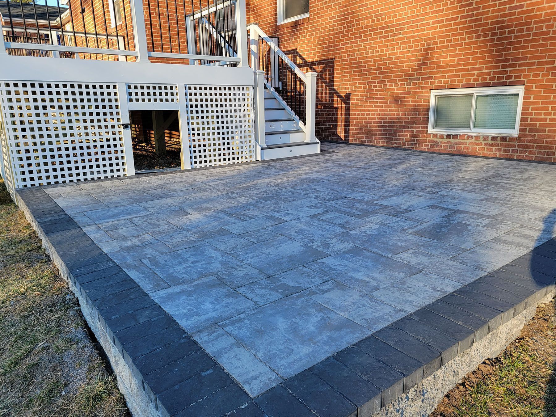 A brick house with a patio and stairs in front of it.