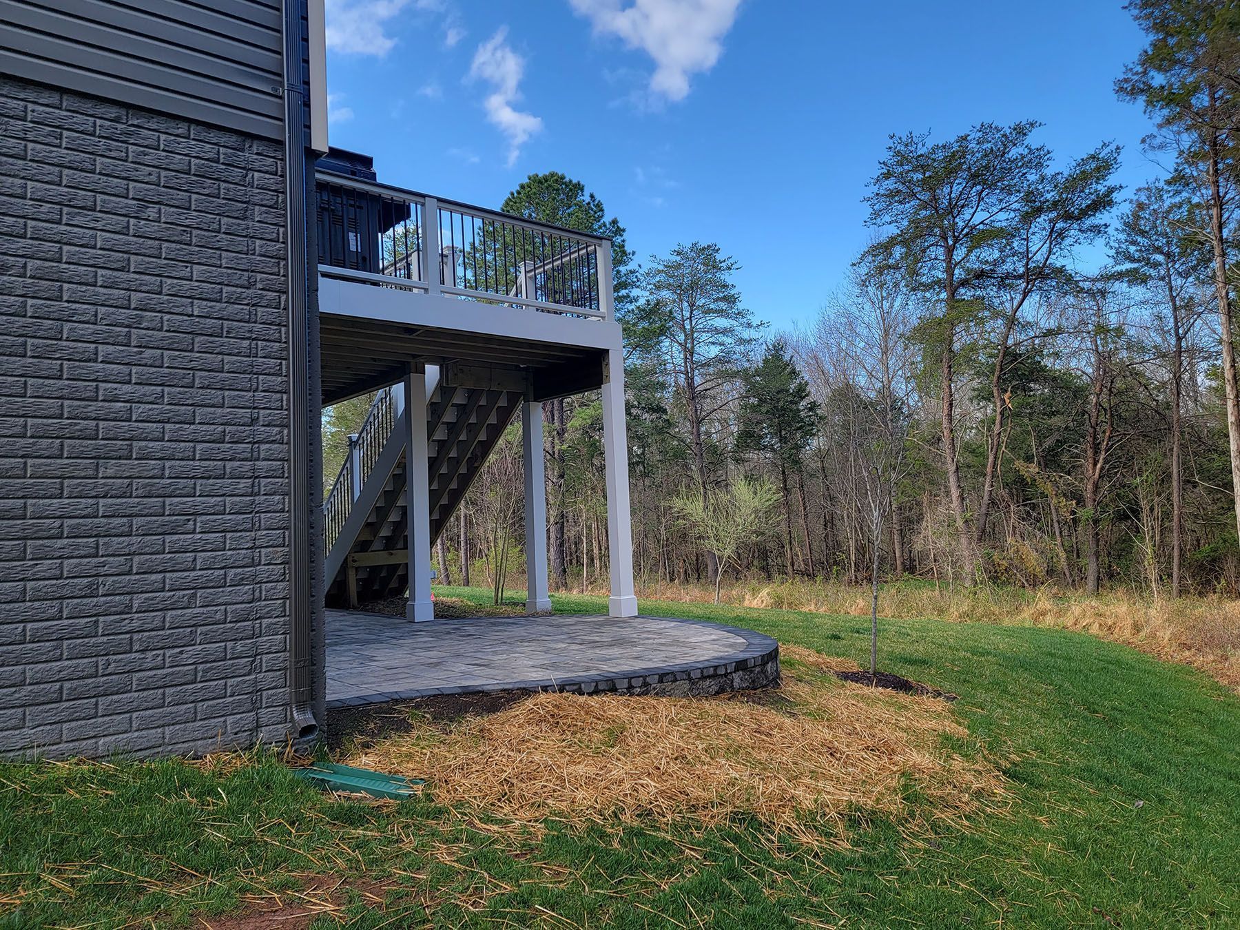 A house with a large deck and stairs in the backyard.