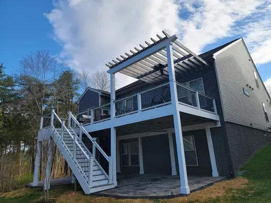 The back of a house with a large deck and stairs.