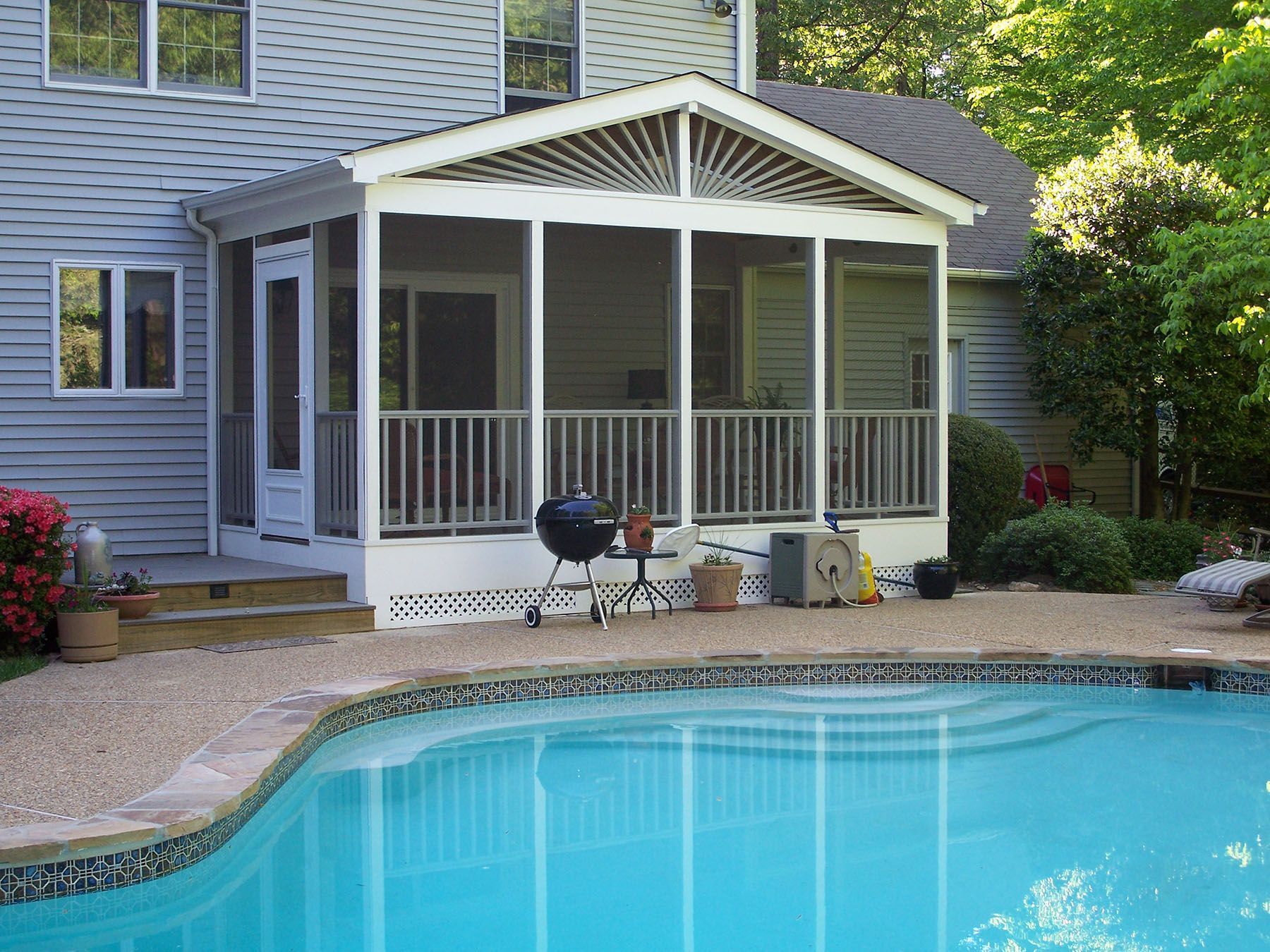 A screened in porch next to a swimming pool