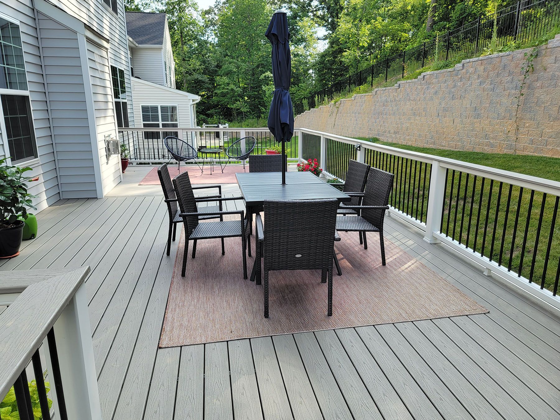 There is a table and chairs on the deck with an umbrella.