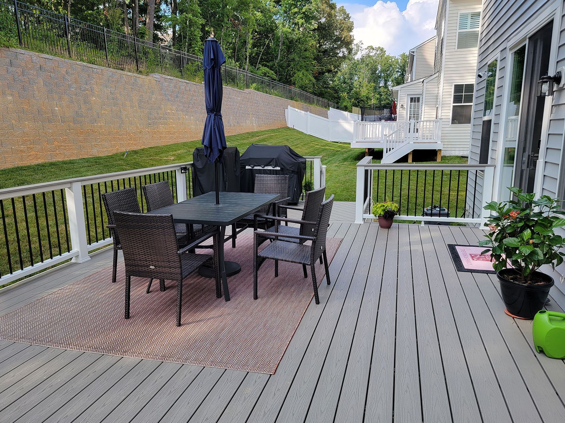 There is a table and chairs on the deck with an umbrella.