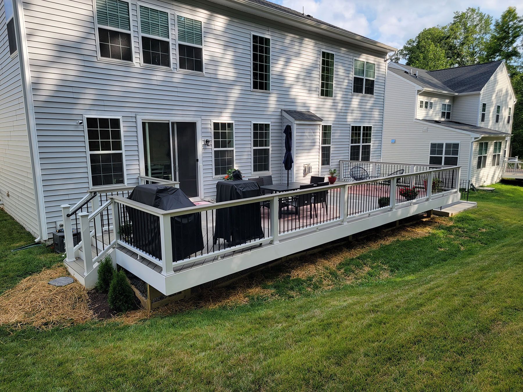 A large white house with a large deck in front of it.