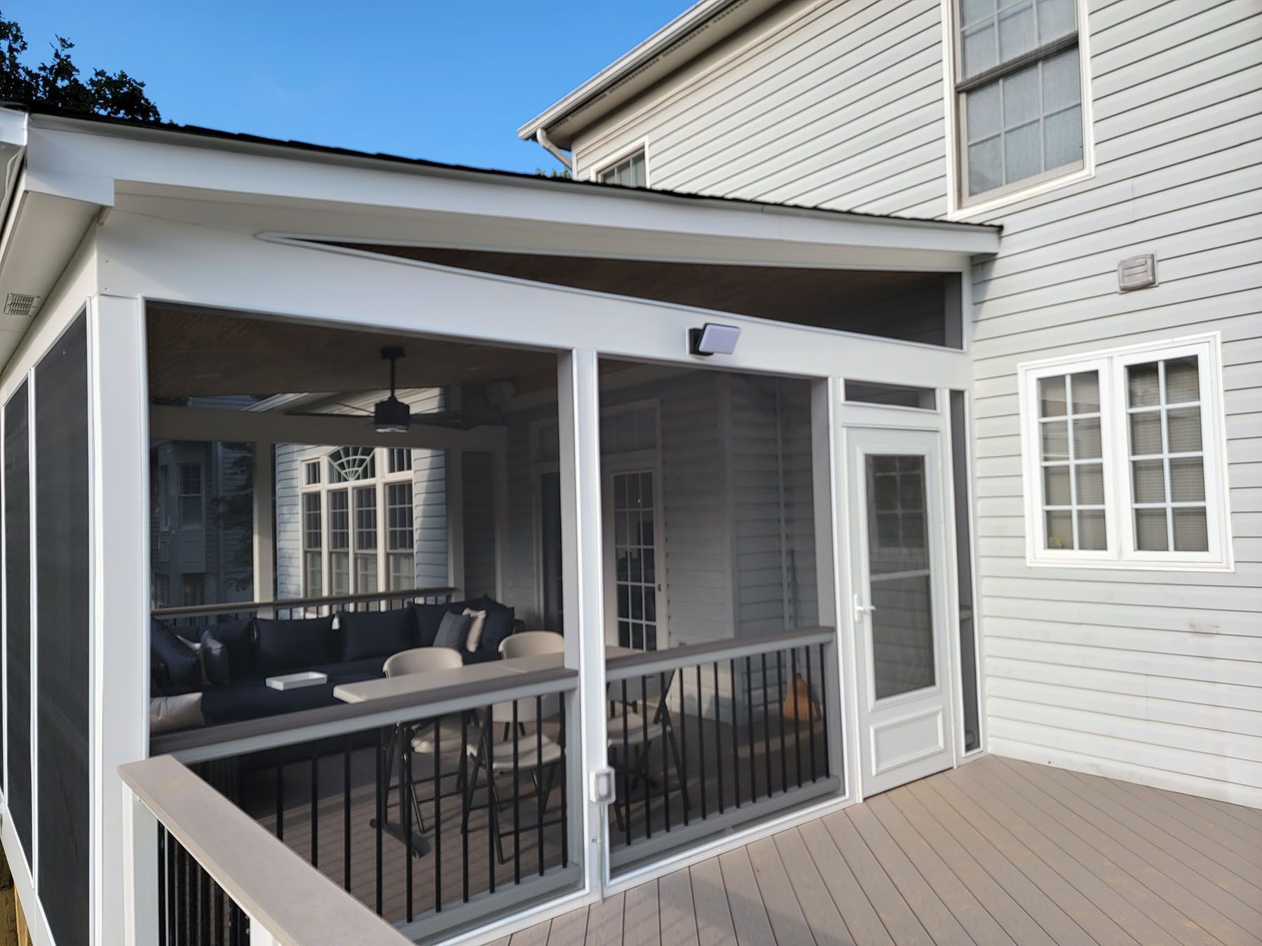 A screened in porch on the side of a house
