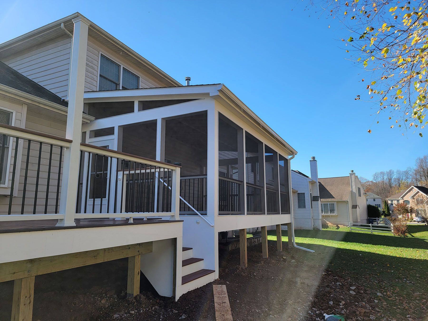 A screened in porch on the side of a house.