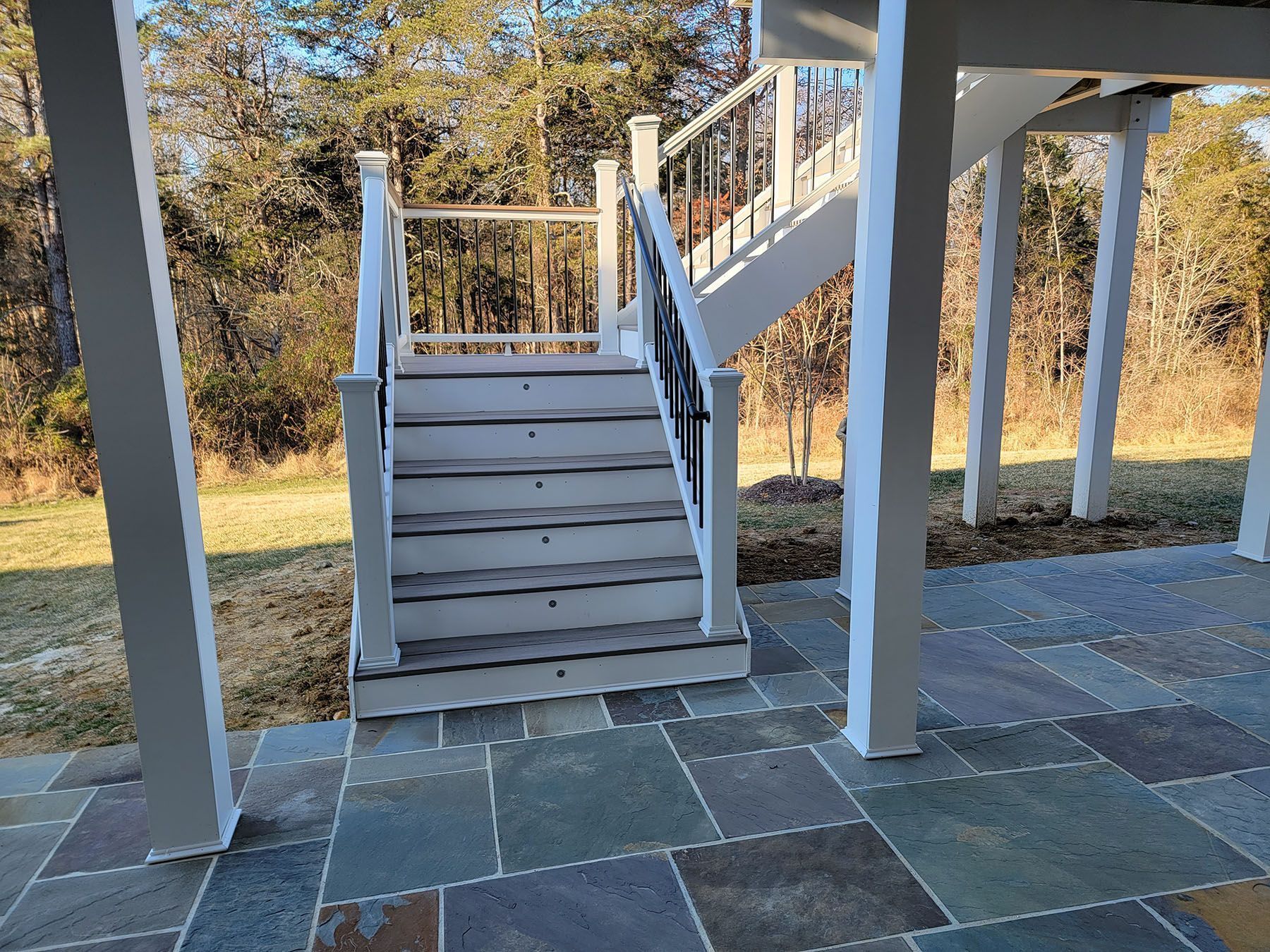 A white deck with stairs leading up to it