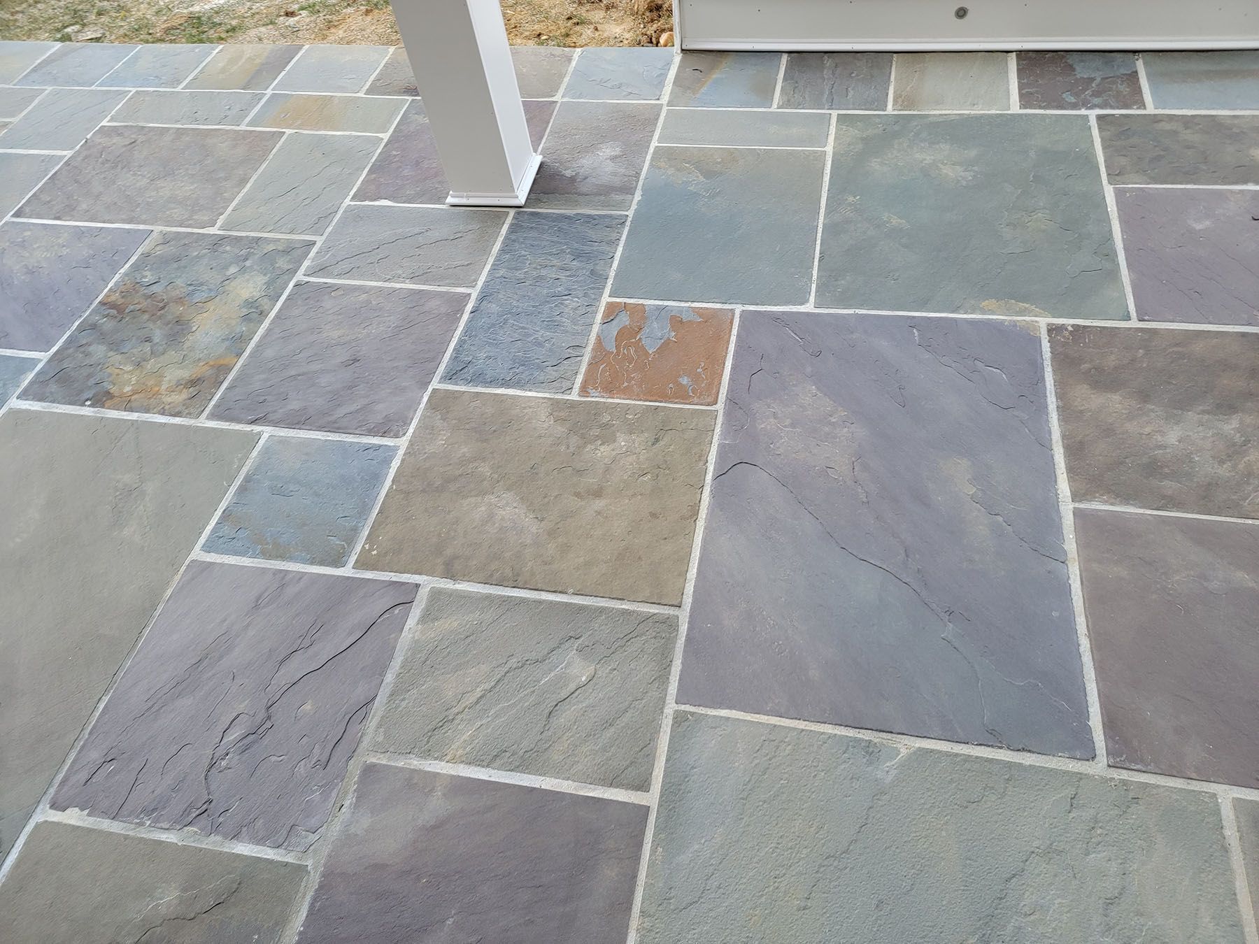 A tiled floor with a white post in the background