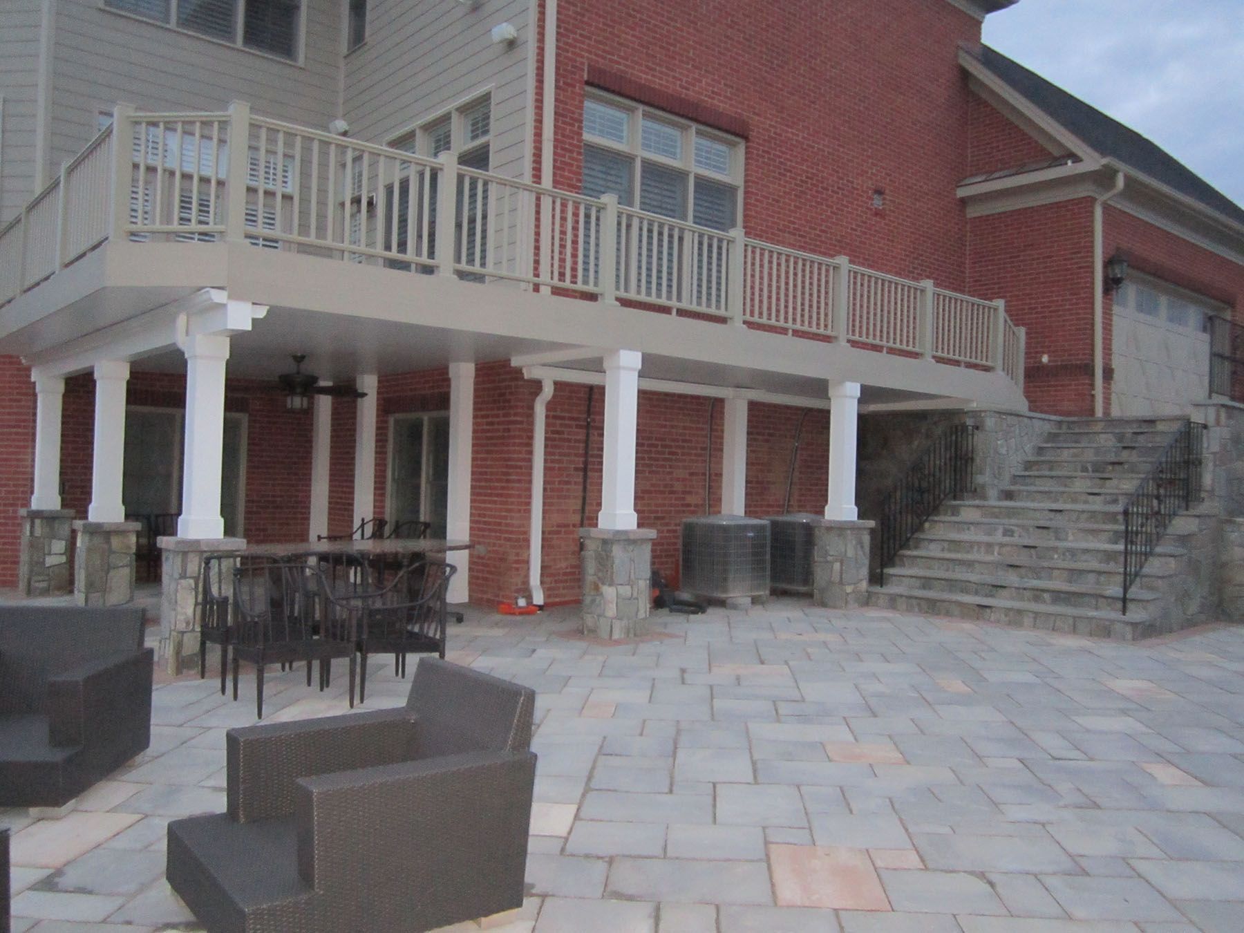 A large brick house with a large deck and stairs