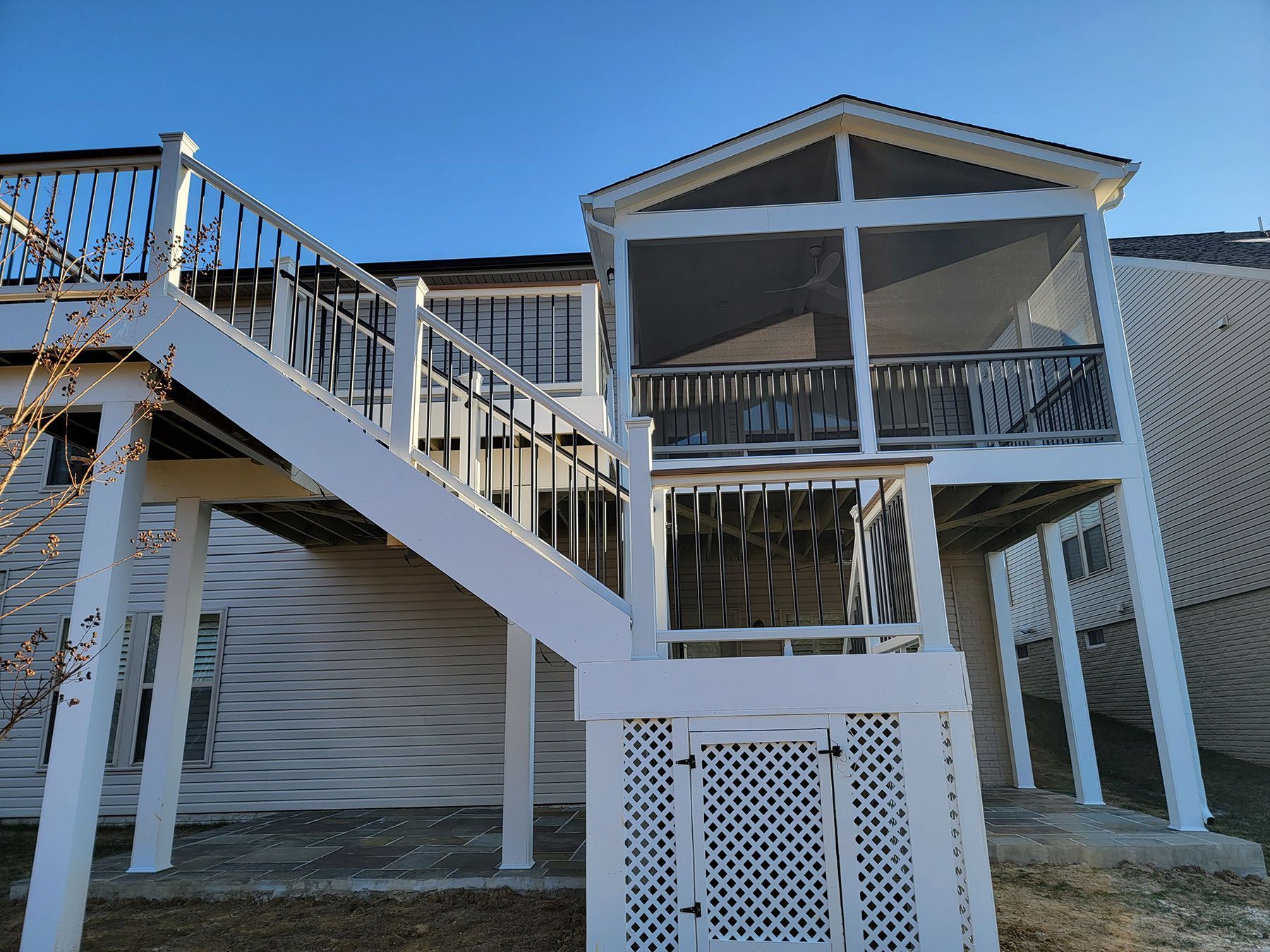 A white house with a screened in porch and stairs