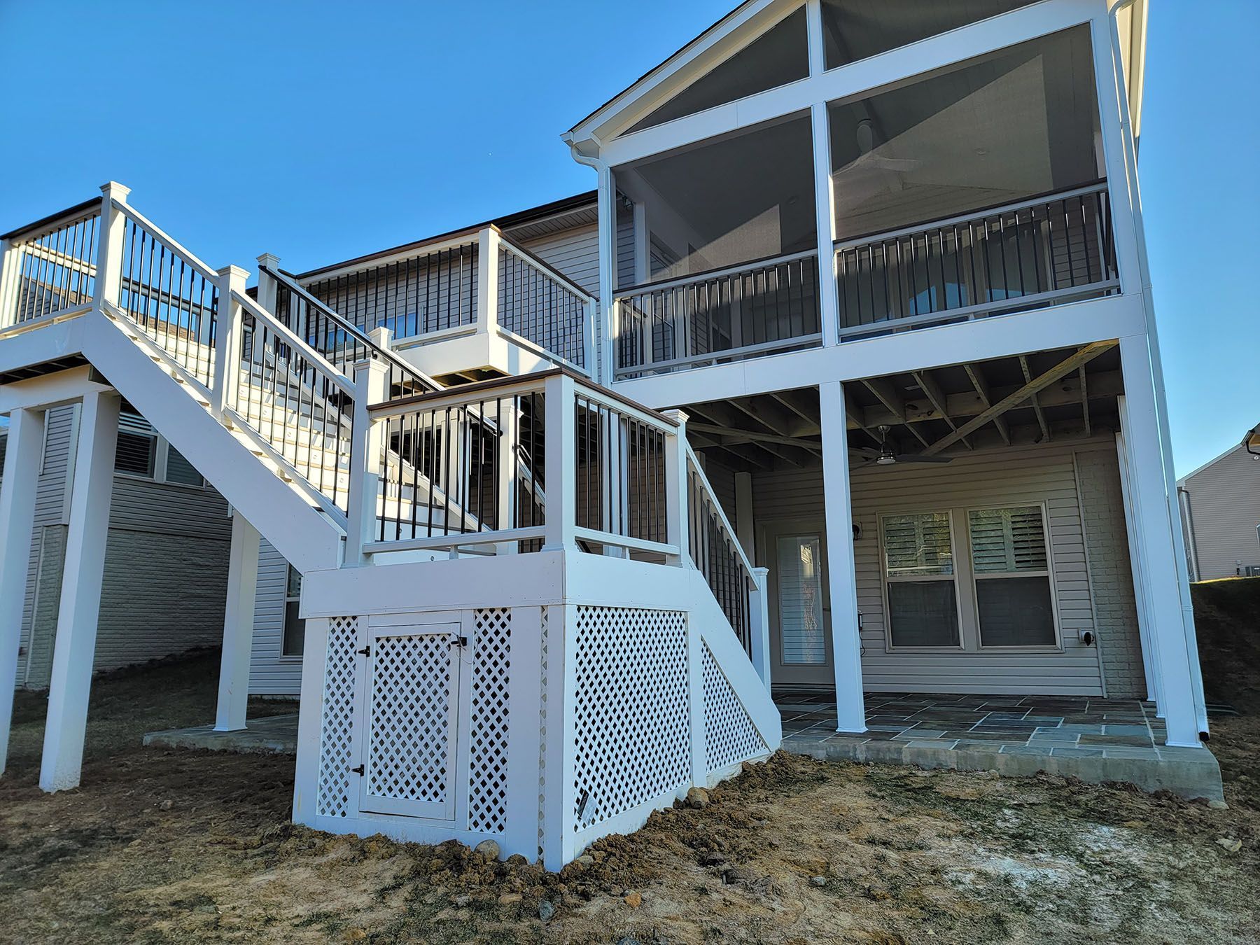 A large house with a large deck and stairs leading up to it.