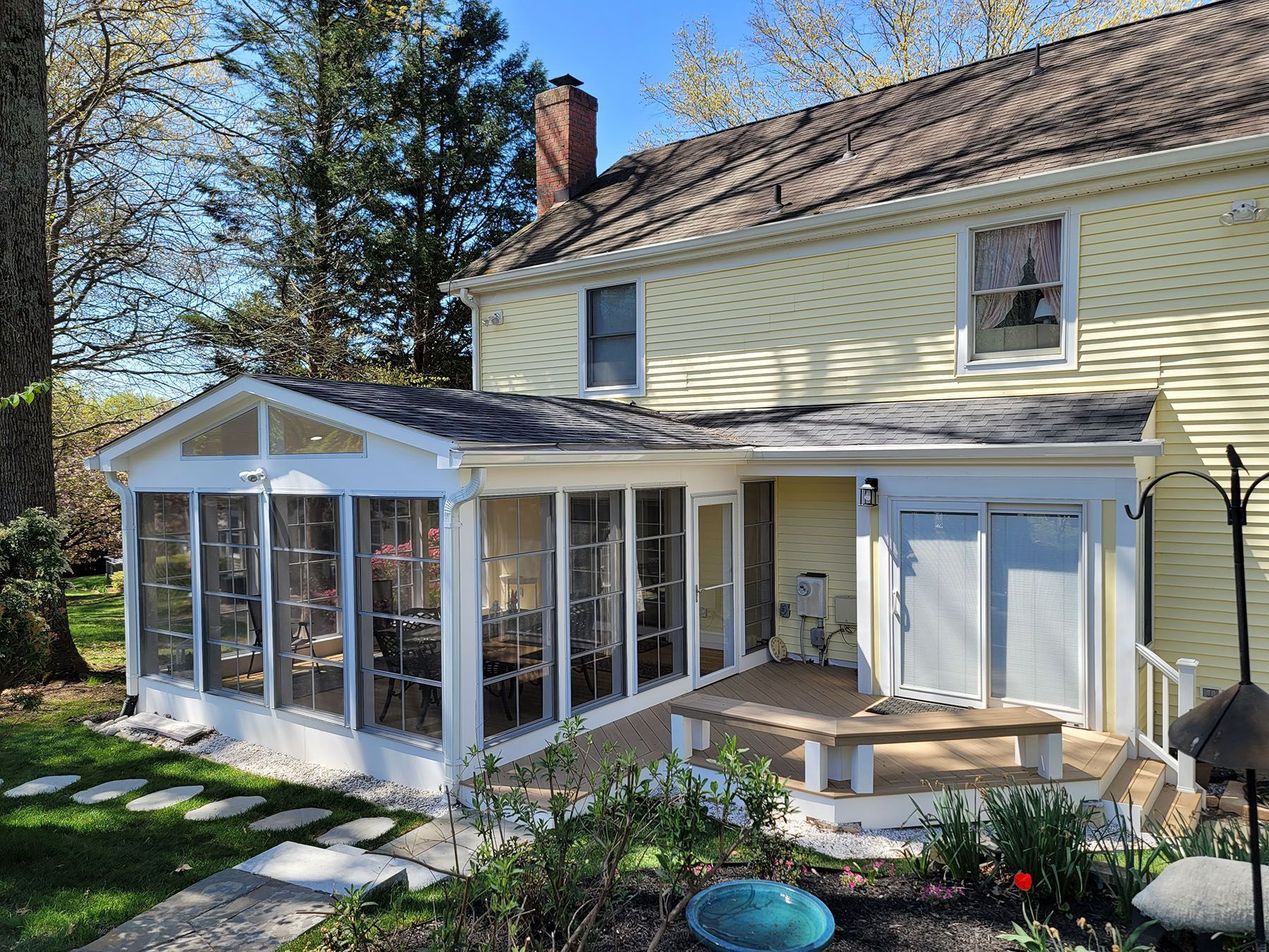 A house with a screened in porch and a walkway leading to it.