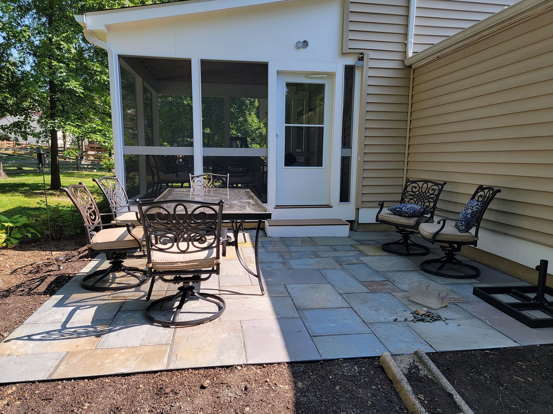 A screened in porch with a table and chairs