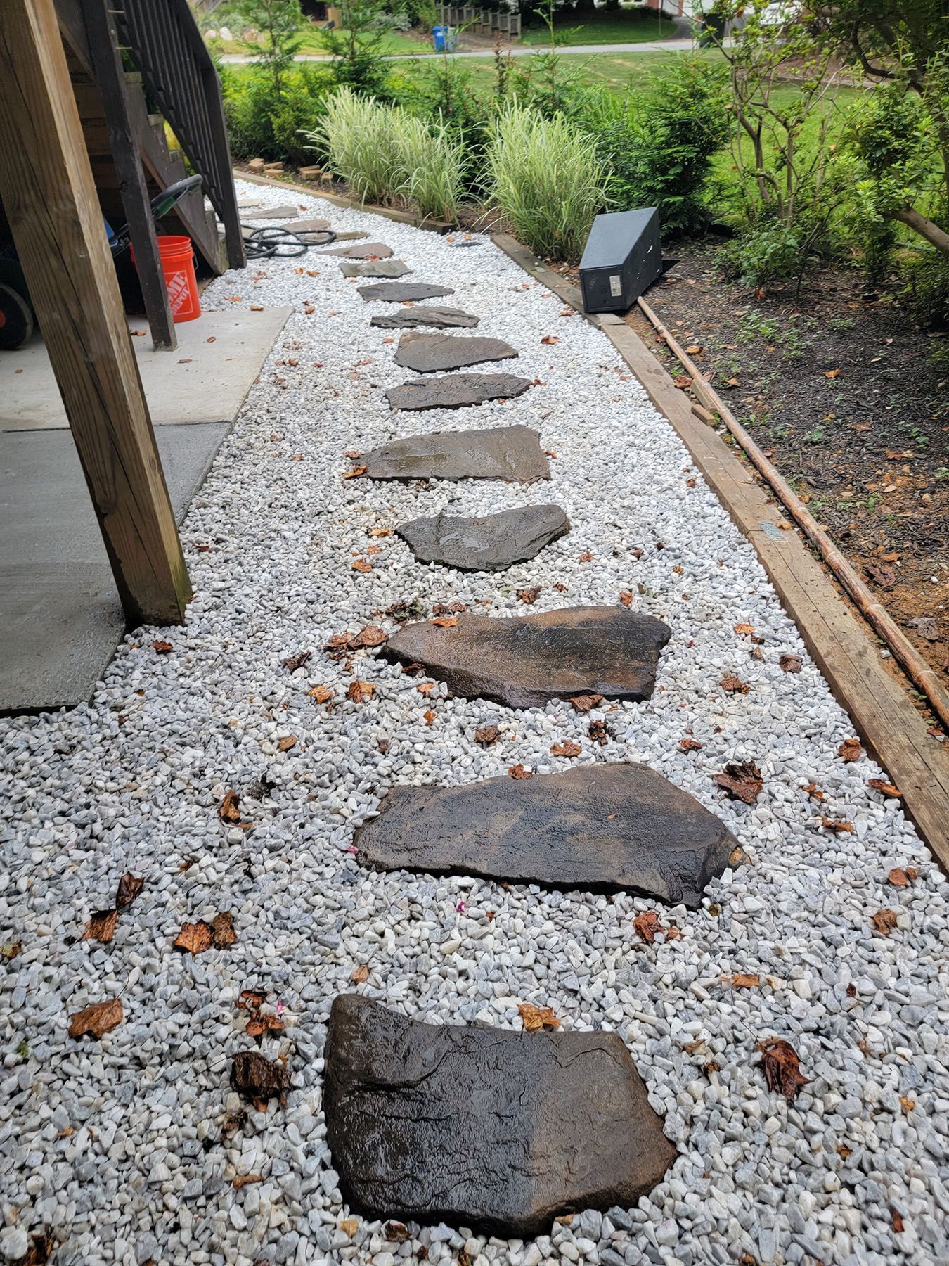 A row of stepping stones lined up on a gravel path.