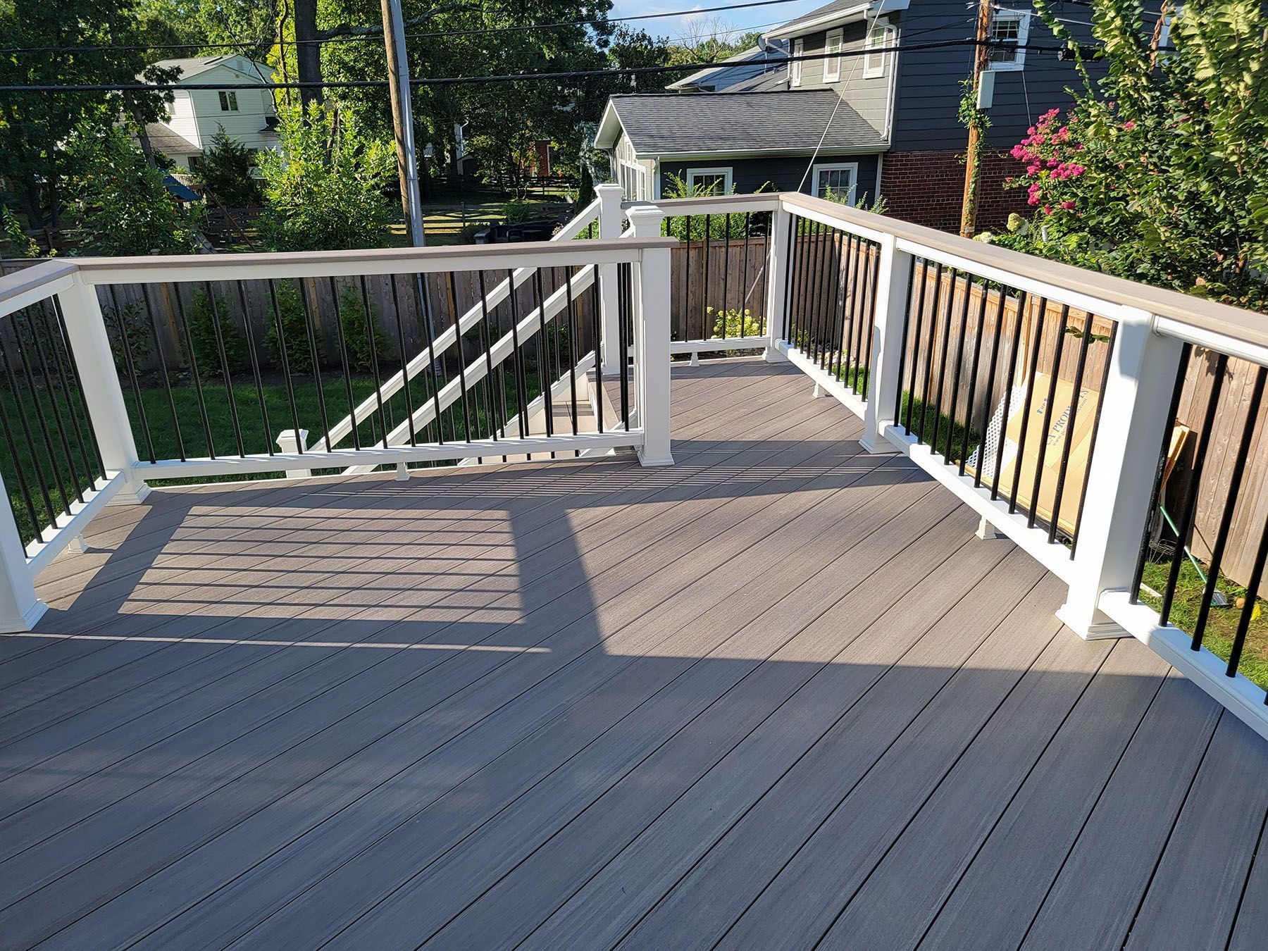 A wooden deck with a white railing and stairs leading up to it.