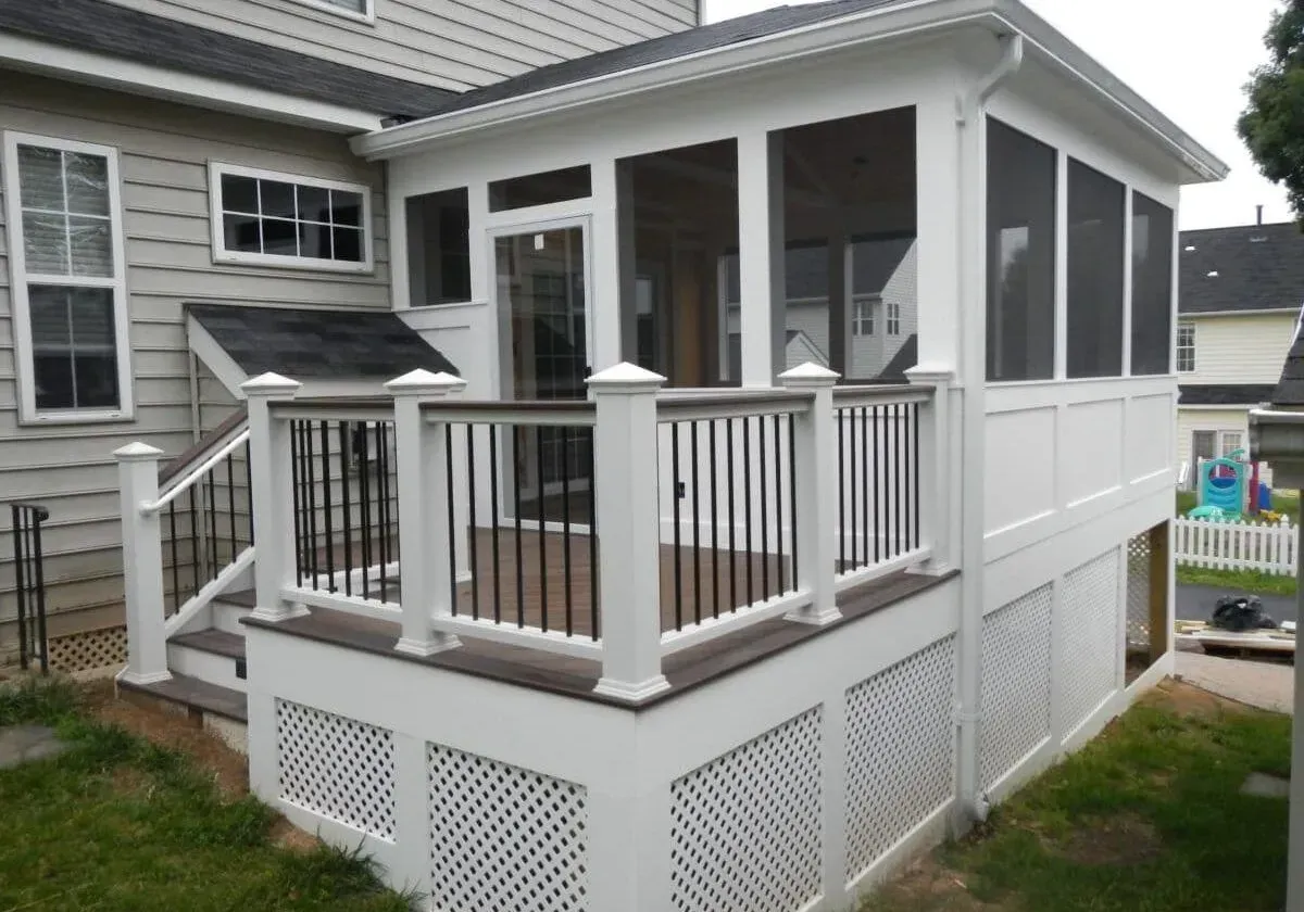 A screened in porch in the backyard of a house