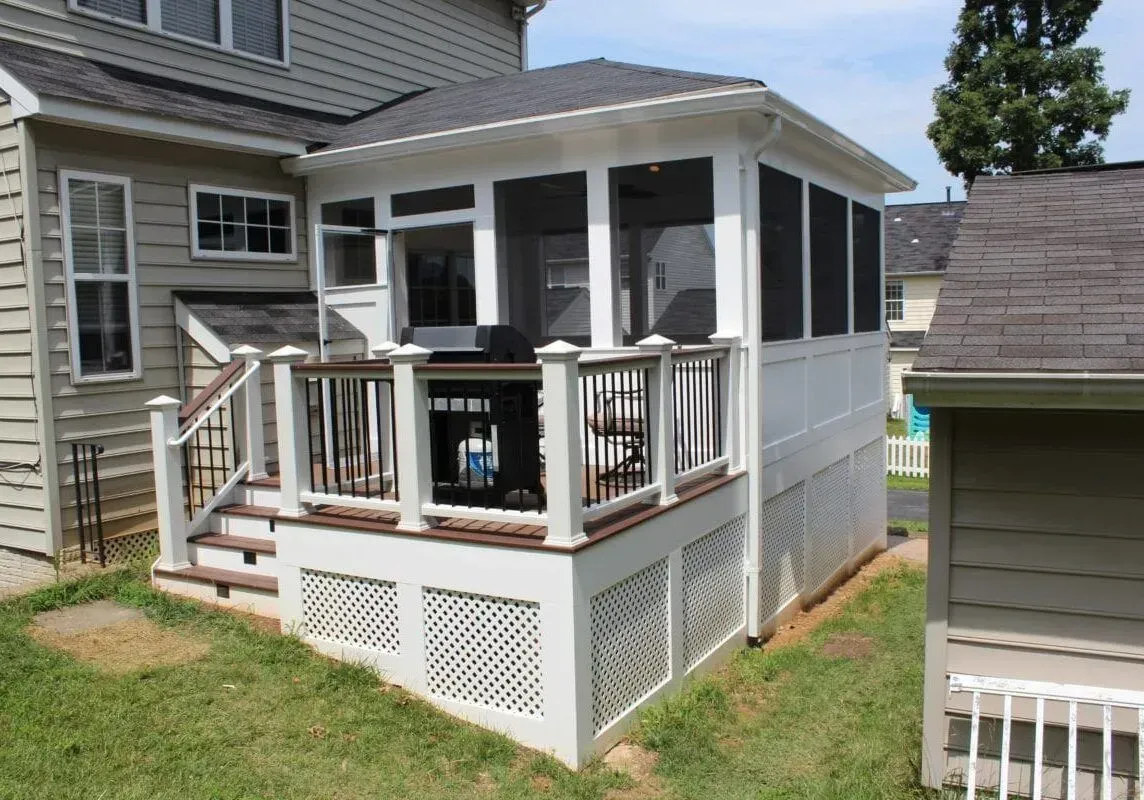 A screened in porch in the backyard of a house