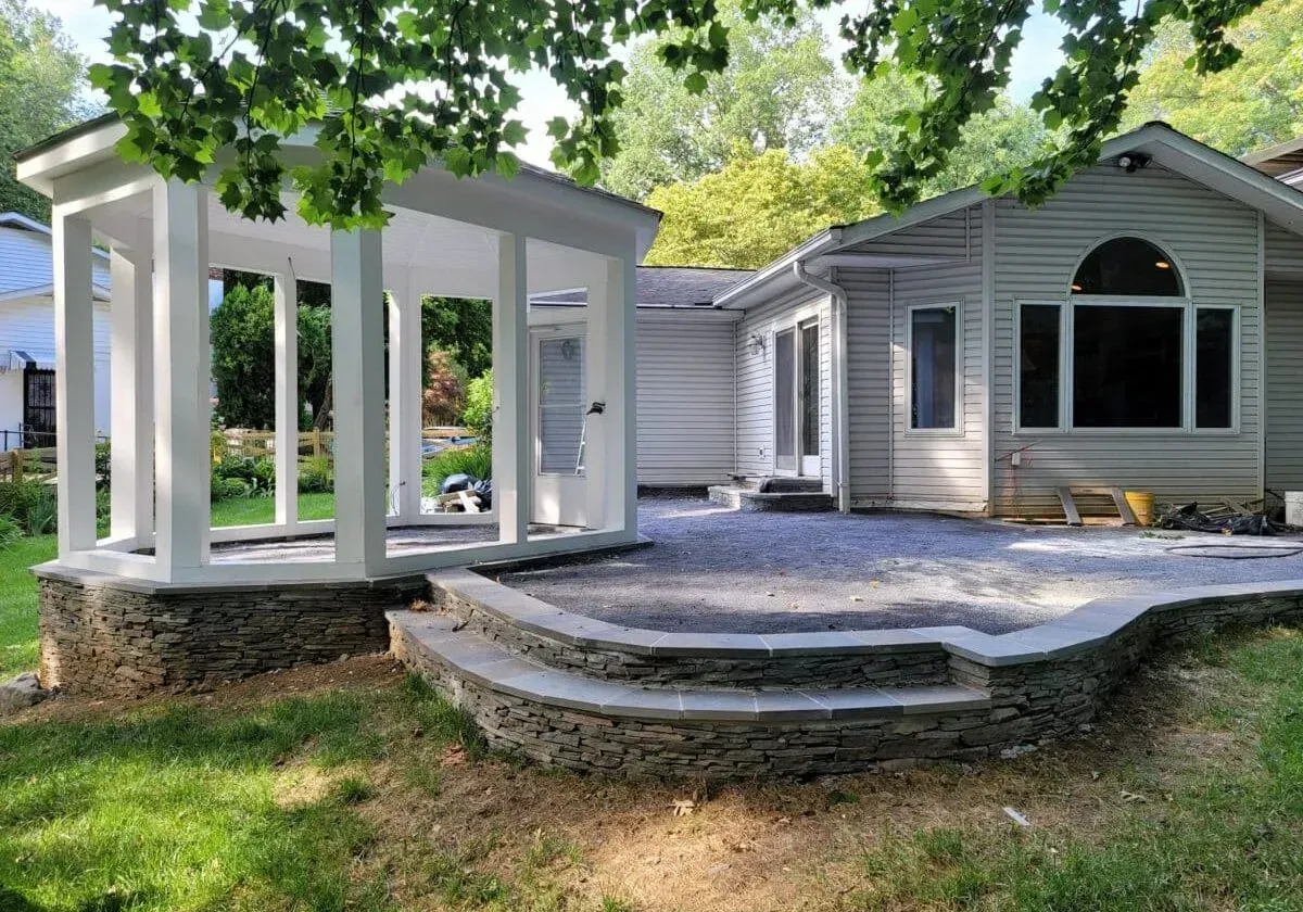 A house with a patio and a gazebo in front of it.