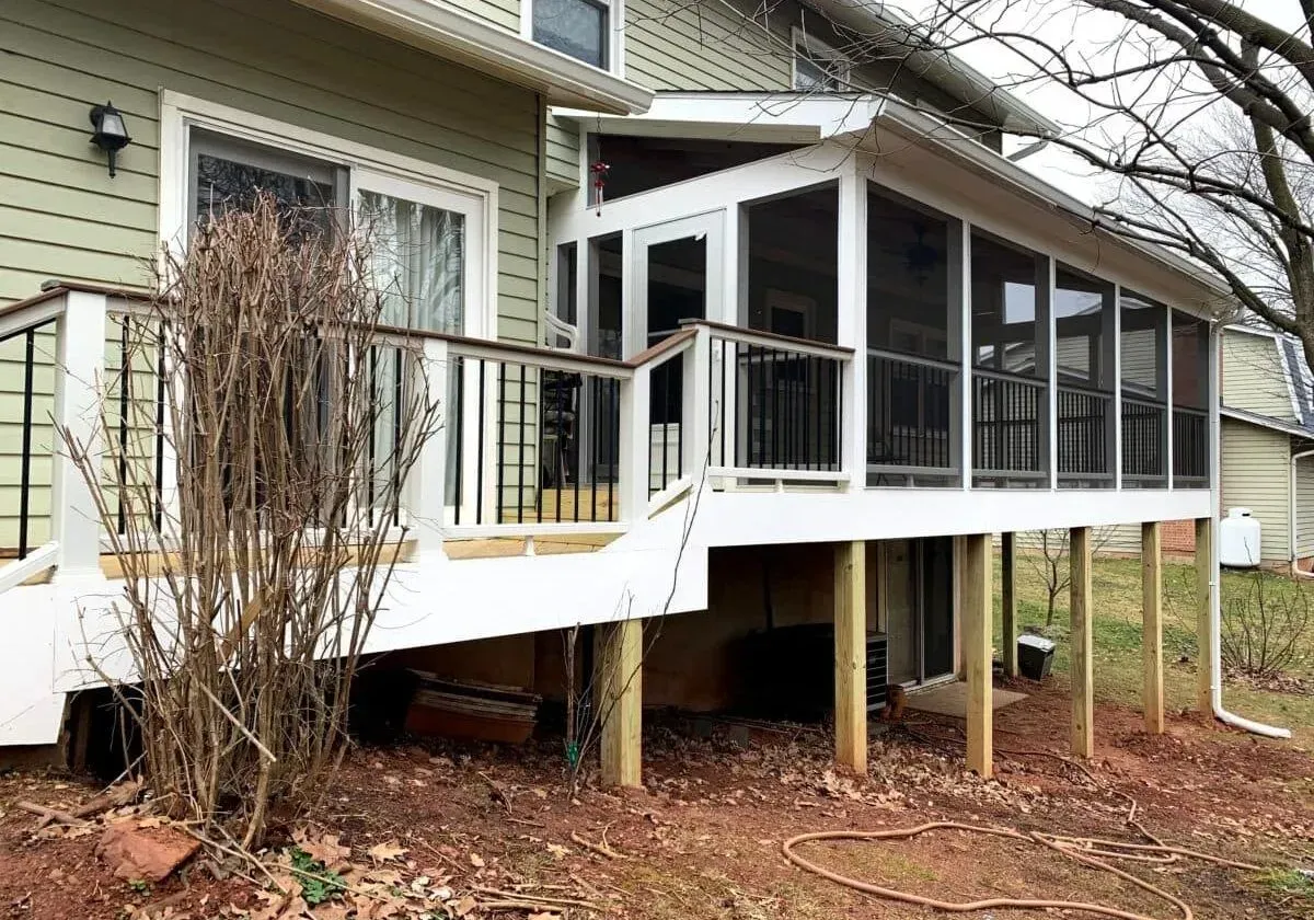 A screened in porch is attached to the back of a house.