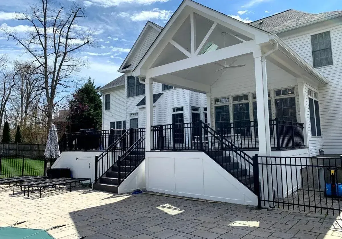 A large white house with a large porch and stairs leading to it.