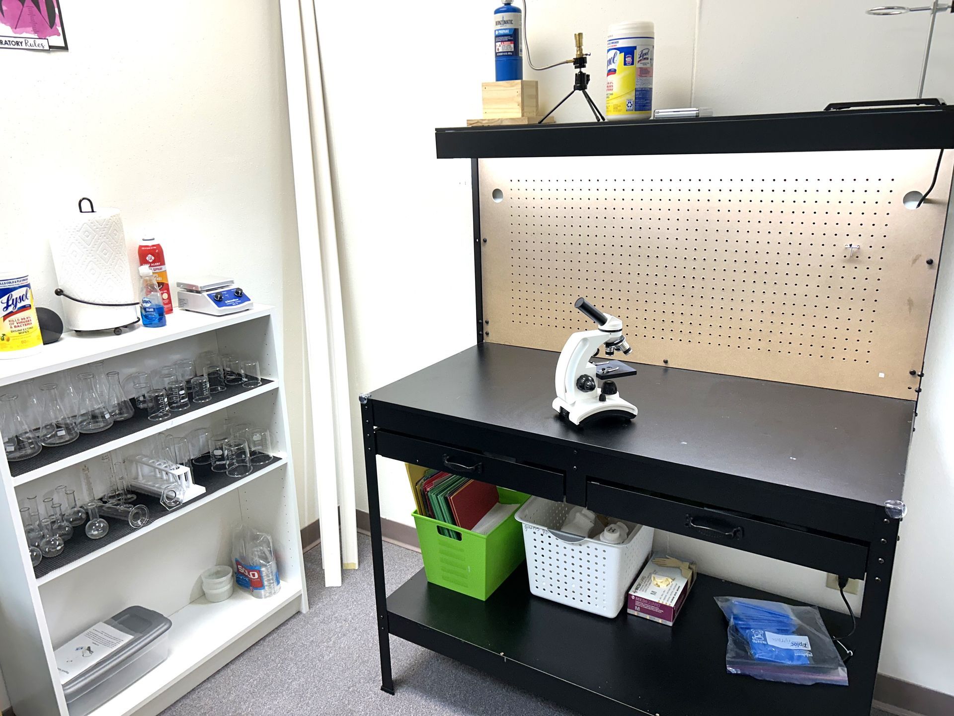 A microscope is sitting on a table in a room.