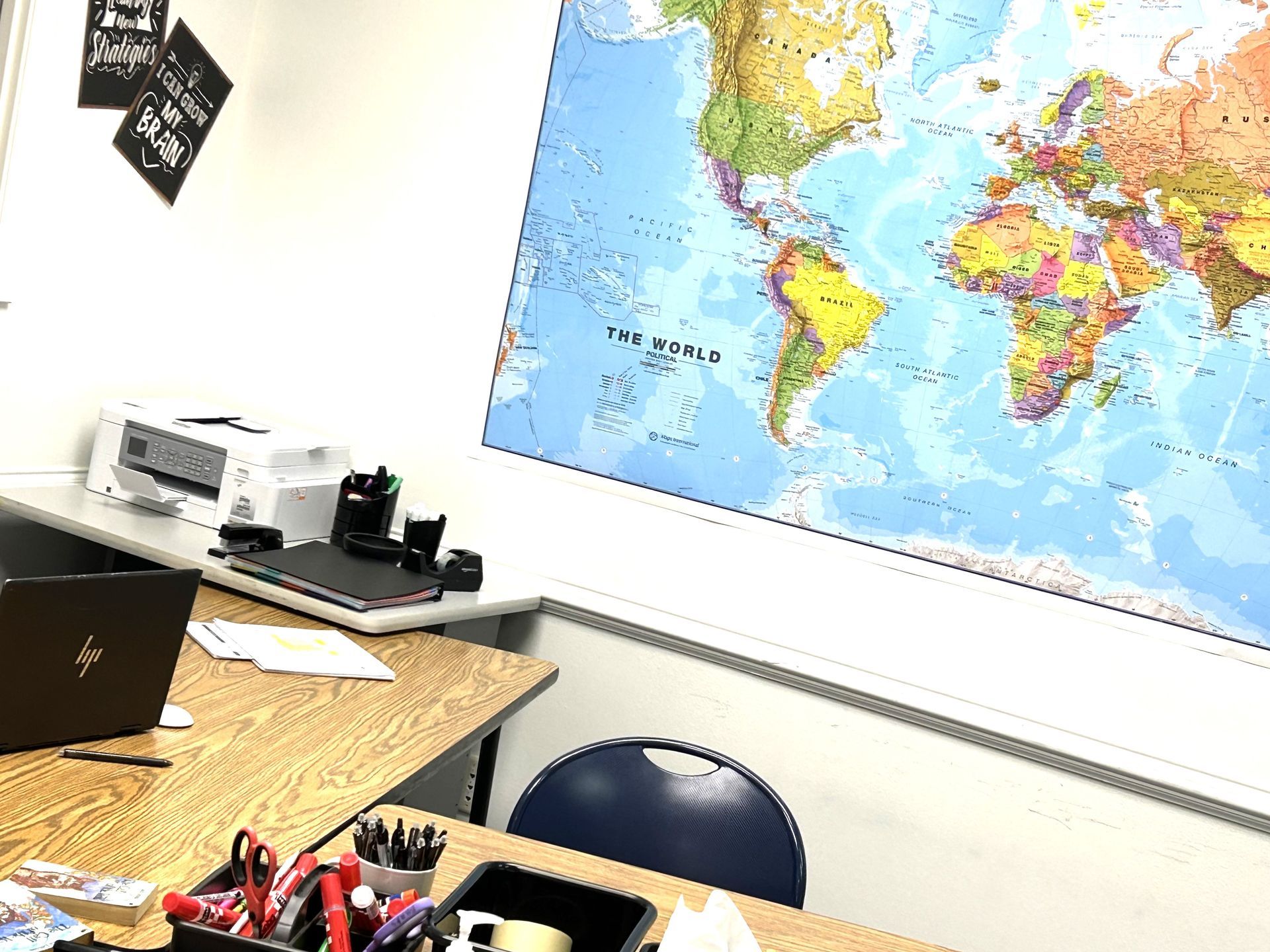 A classroom with a large map of the world on the wall.