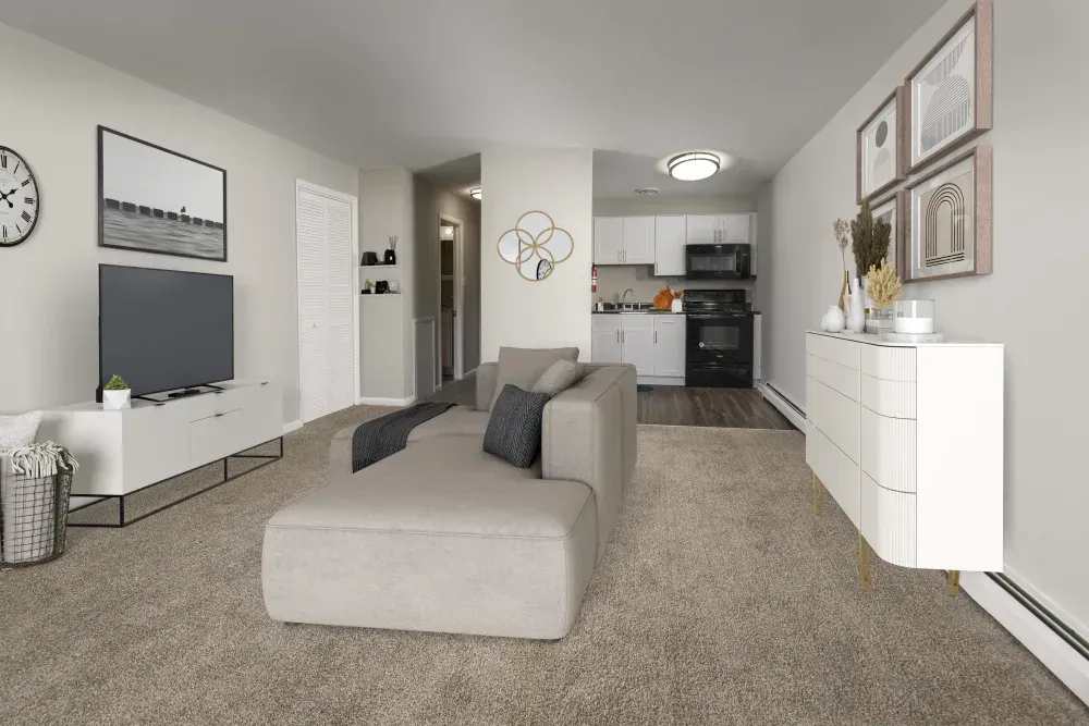 Modern living room with a couch, television, and kitchen in background