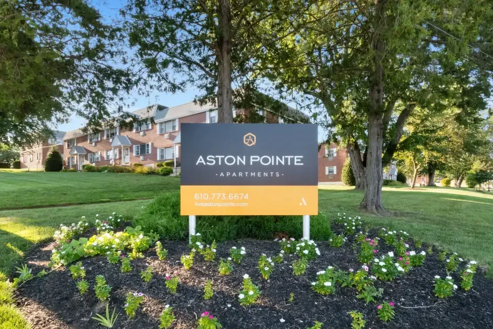 Sign for Aston Pointe Apartments with landscaping