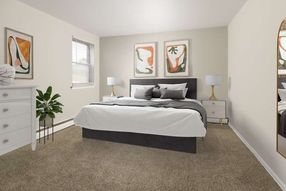 A cozy bedroom featuring a bed with grey bedding and decorative pillows, a dresser, and artwork on the walls.