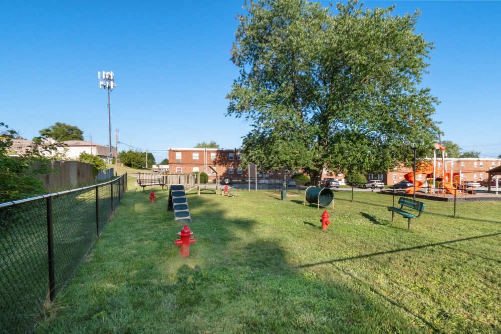 Open green space with play equipment and a park bench