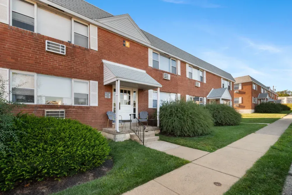 Exterior view of a residential building with landscaping and pathway