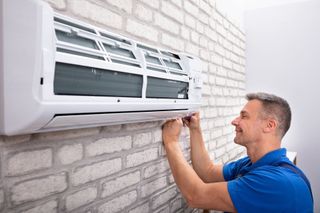 HVAC Contractor — Technician Installing Air Conditioner in Alhambra, IL