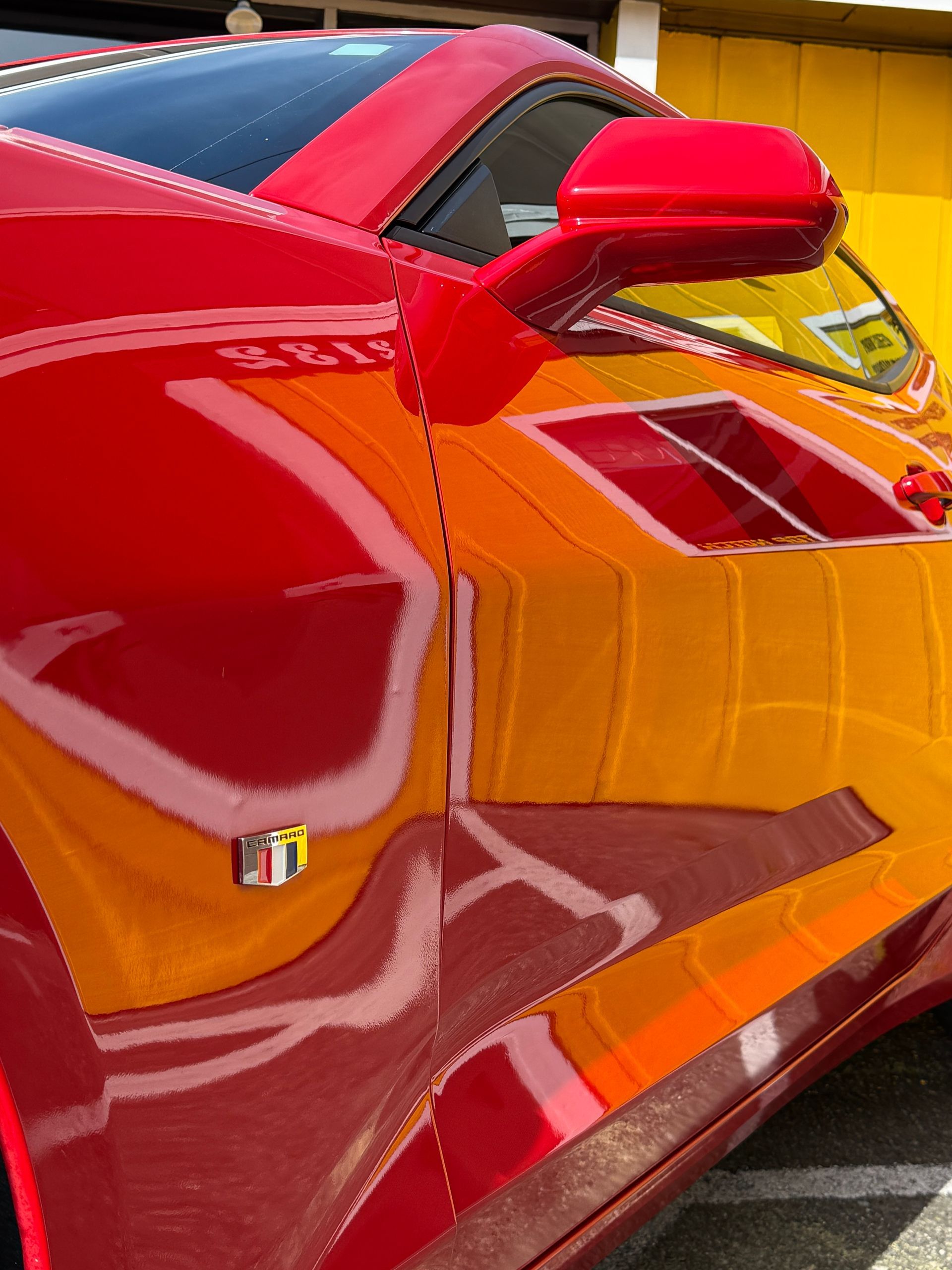 A red car is parked in front of Top Notch Tint & Detail