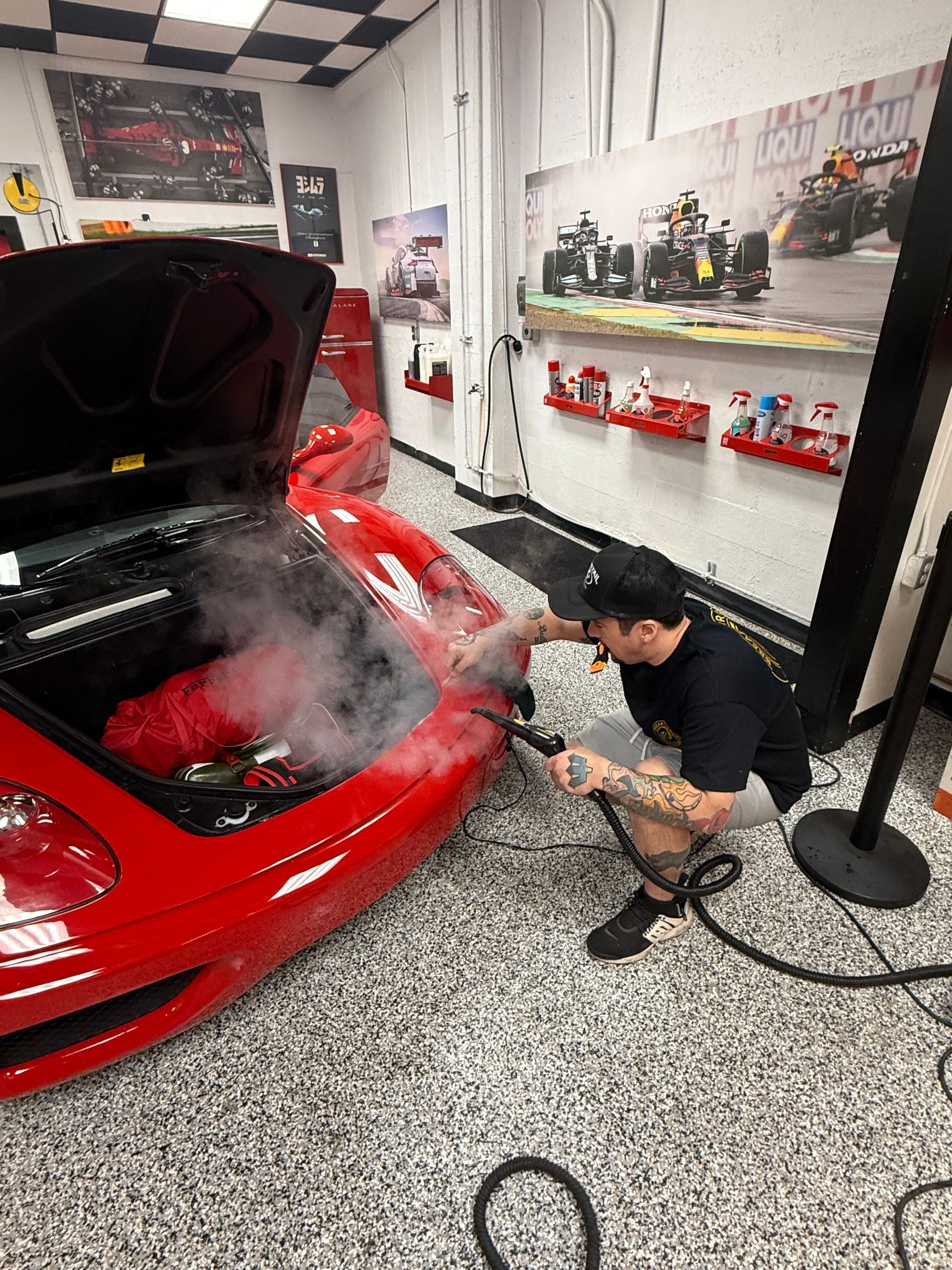 A man is applying a protective film to the front of a car.