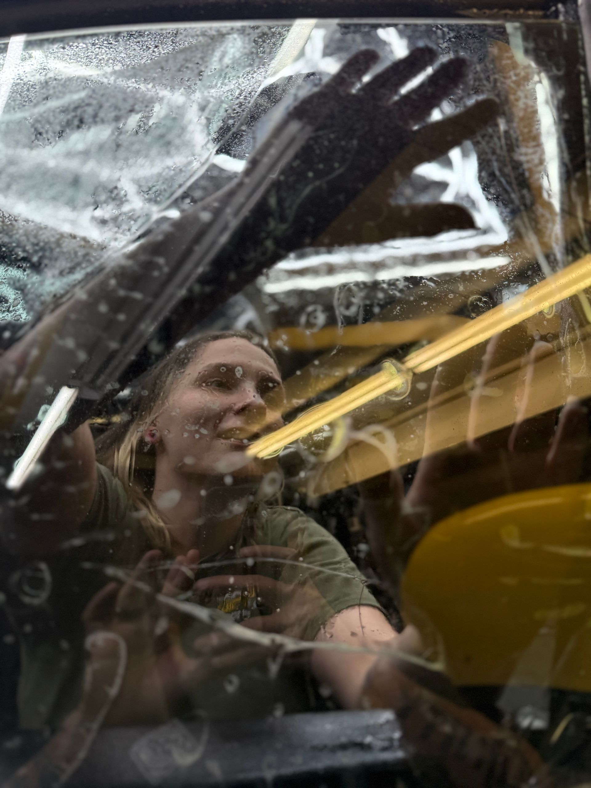 A person is applying window tint to a car window.