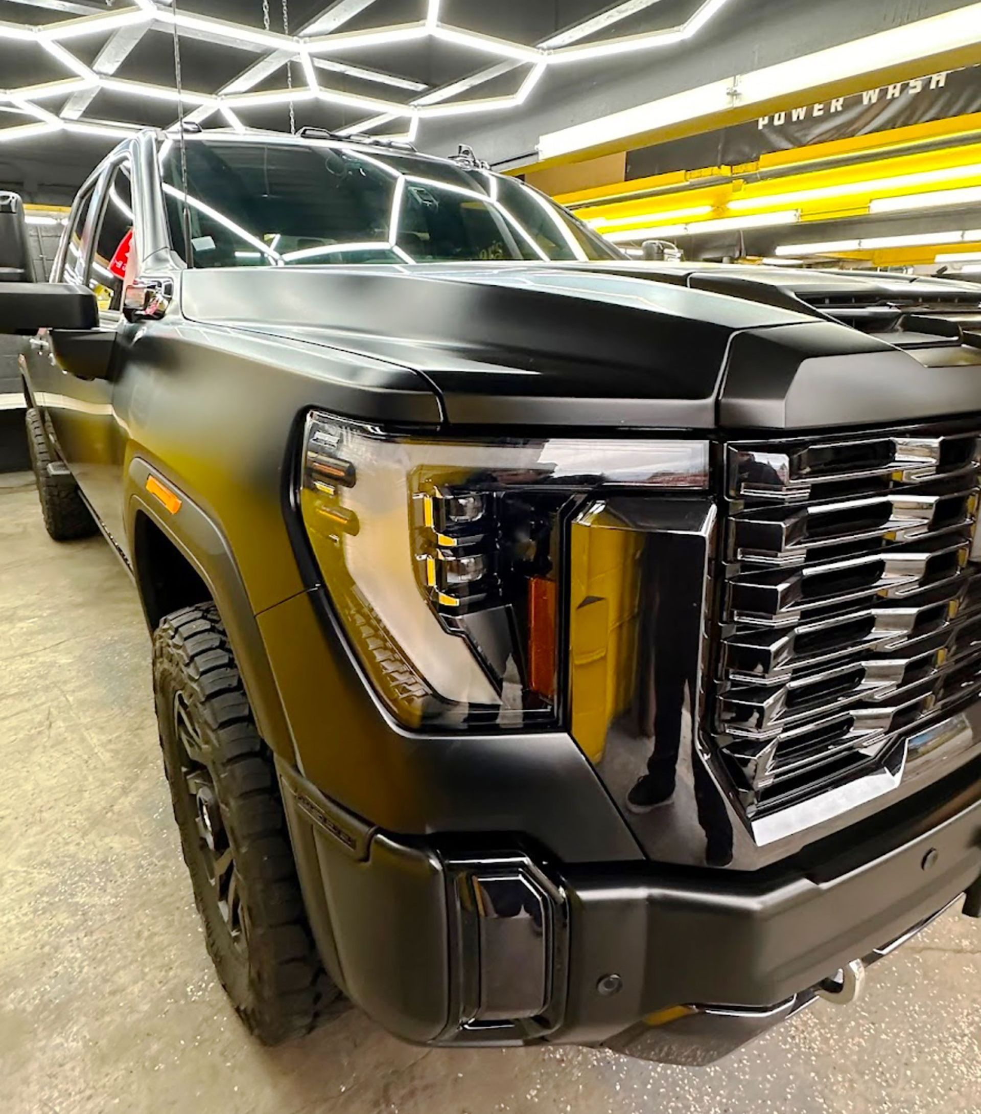 A black truck is parked in a garage.