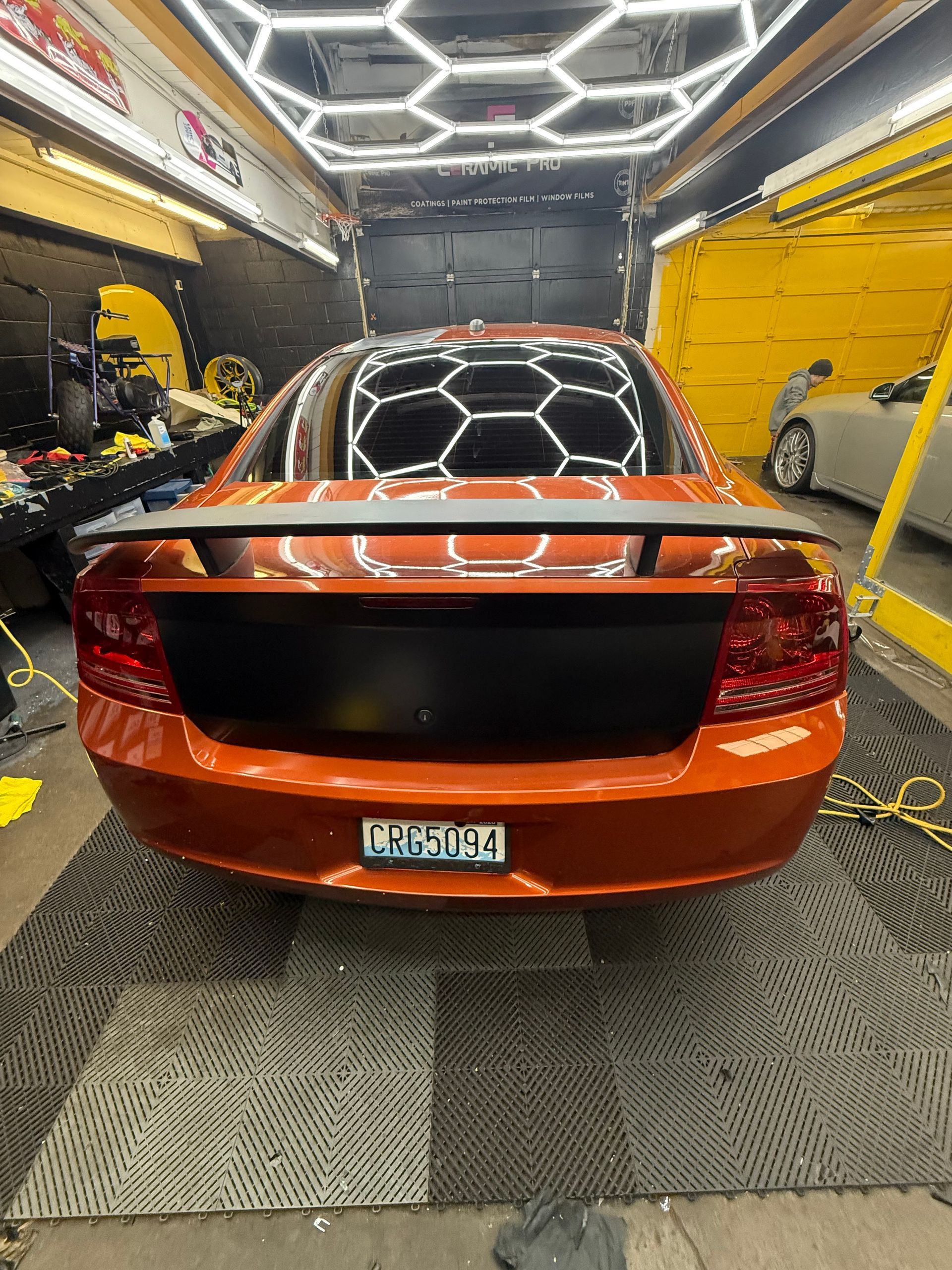 Orange car with black accents in a well-lit garage.