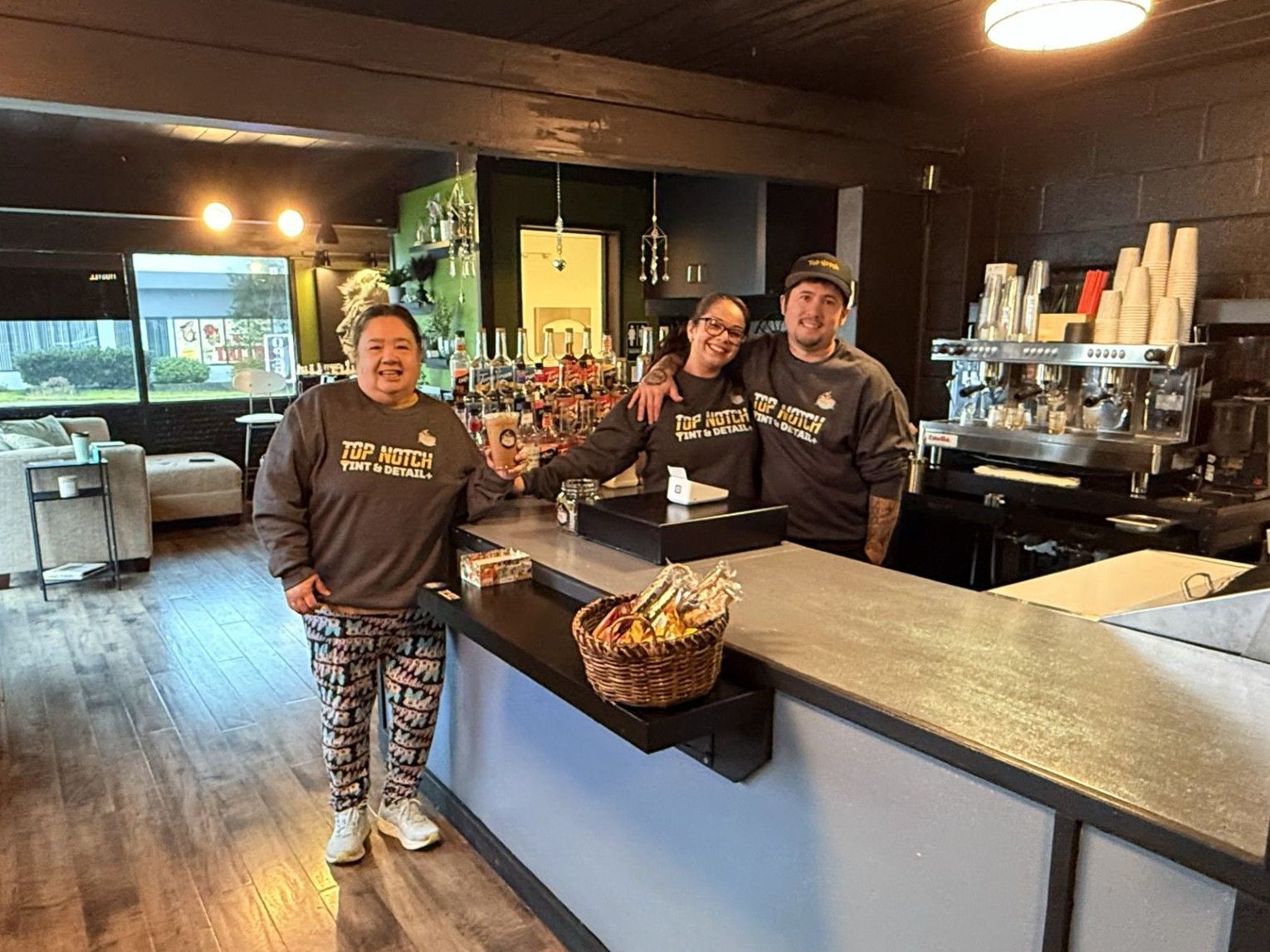 Three people are standing in front of a counter in Jumpin Bean Java