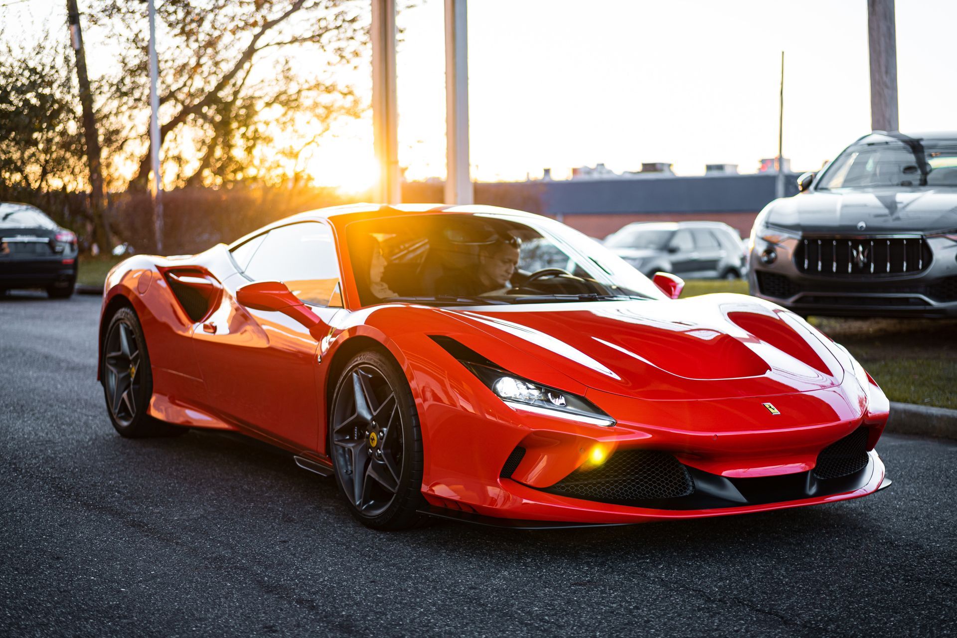 A red sports car is parked in a parking lot.
