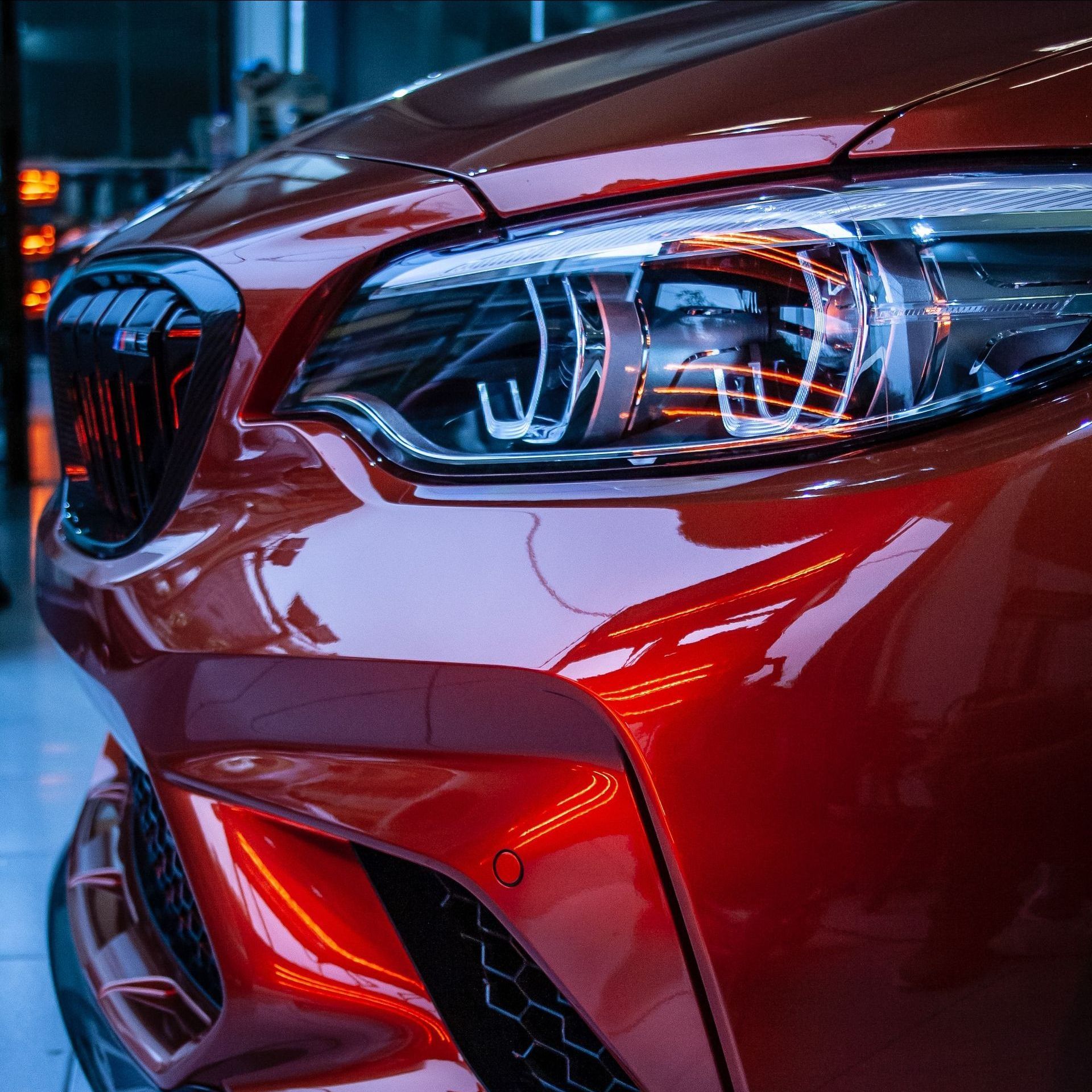 A close up of a red car 's headlight