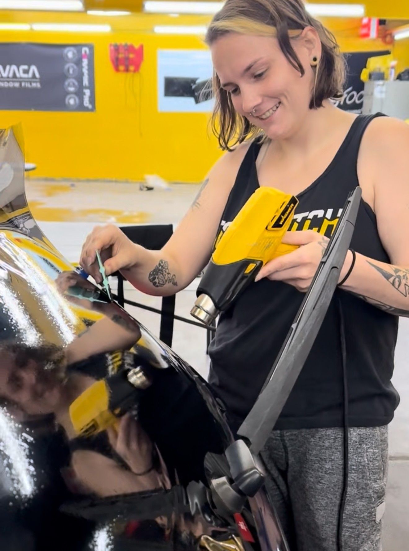 A woman is working on a car in a garage.