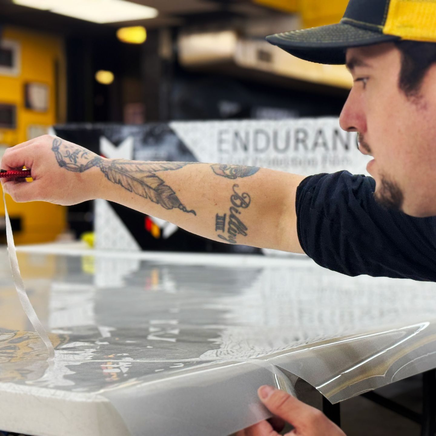 A man with a tattoo on his arm is working on a vehicle