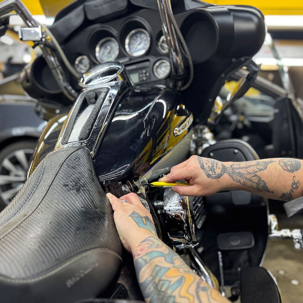 A person with tattoos is working on a motorcycle