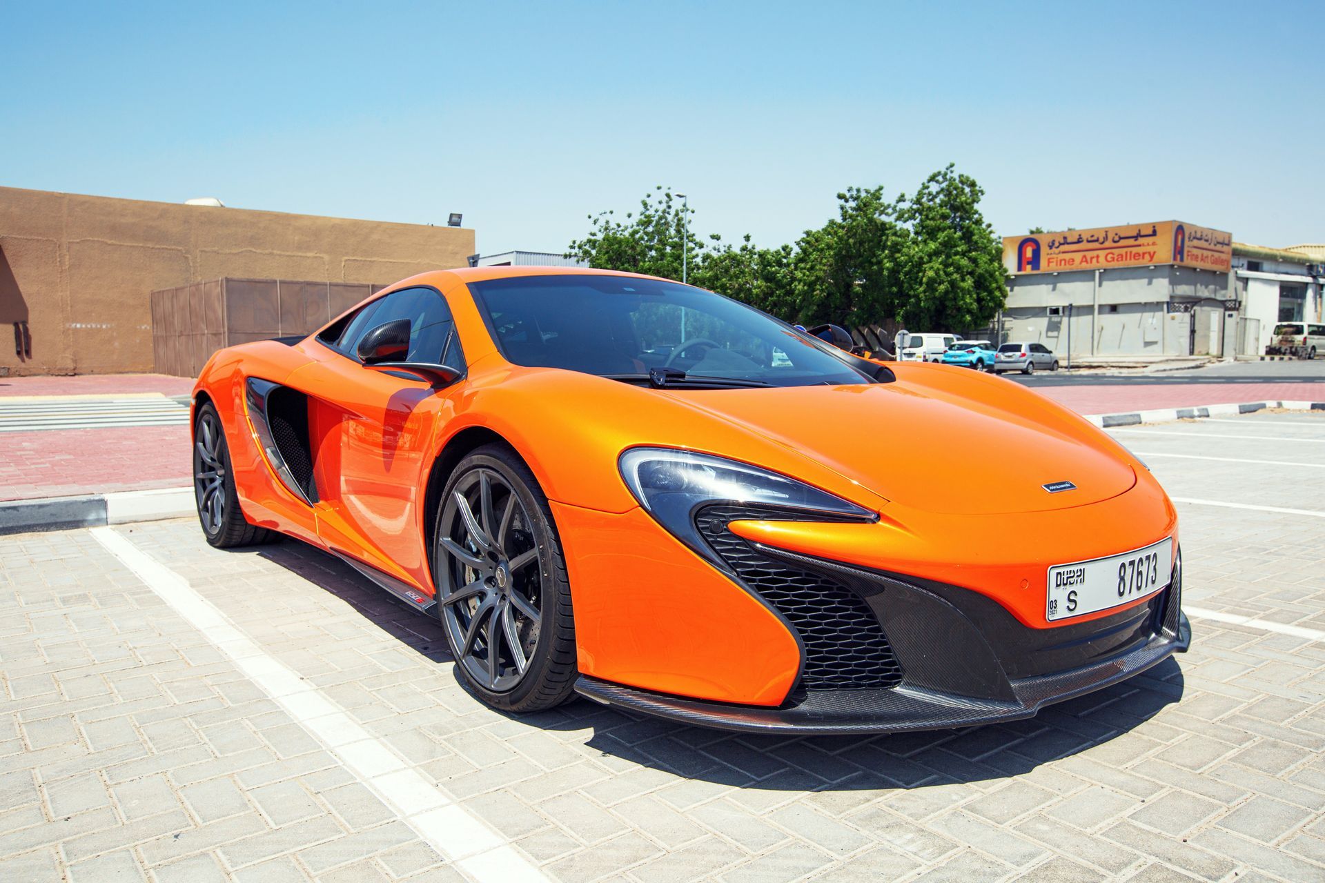 An orange sports car is parked in a parking lot.