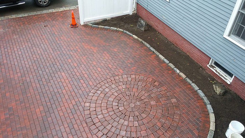 An aerial view of a brick driveway in front of a house.