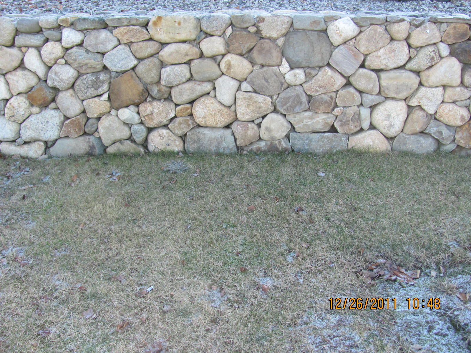A stone wall with a grassy area in front of it