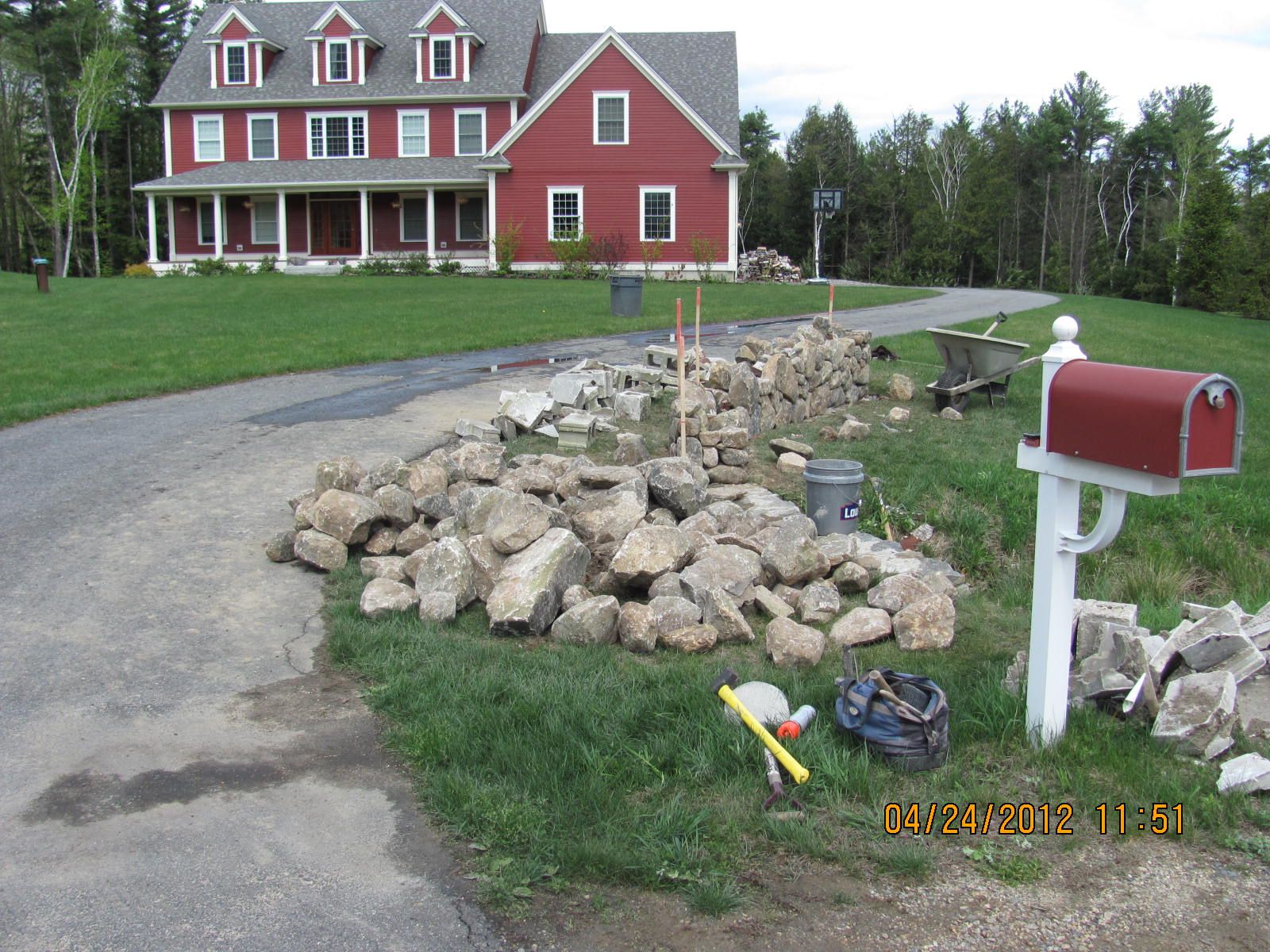 A red mailbox sits in front of a large red house